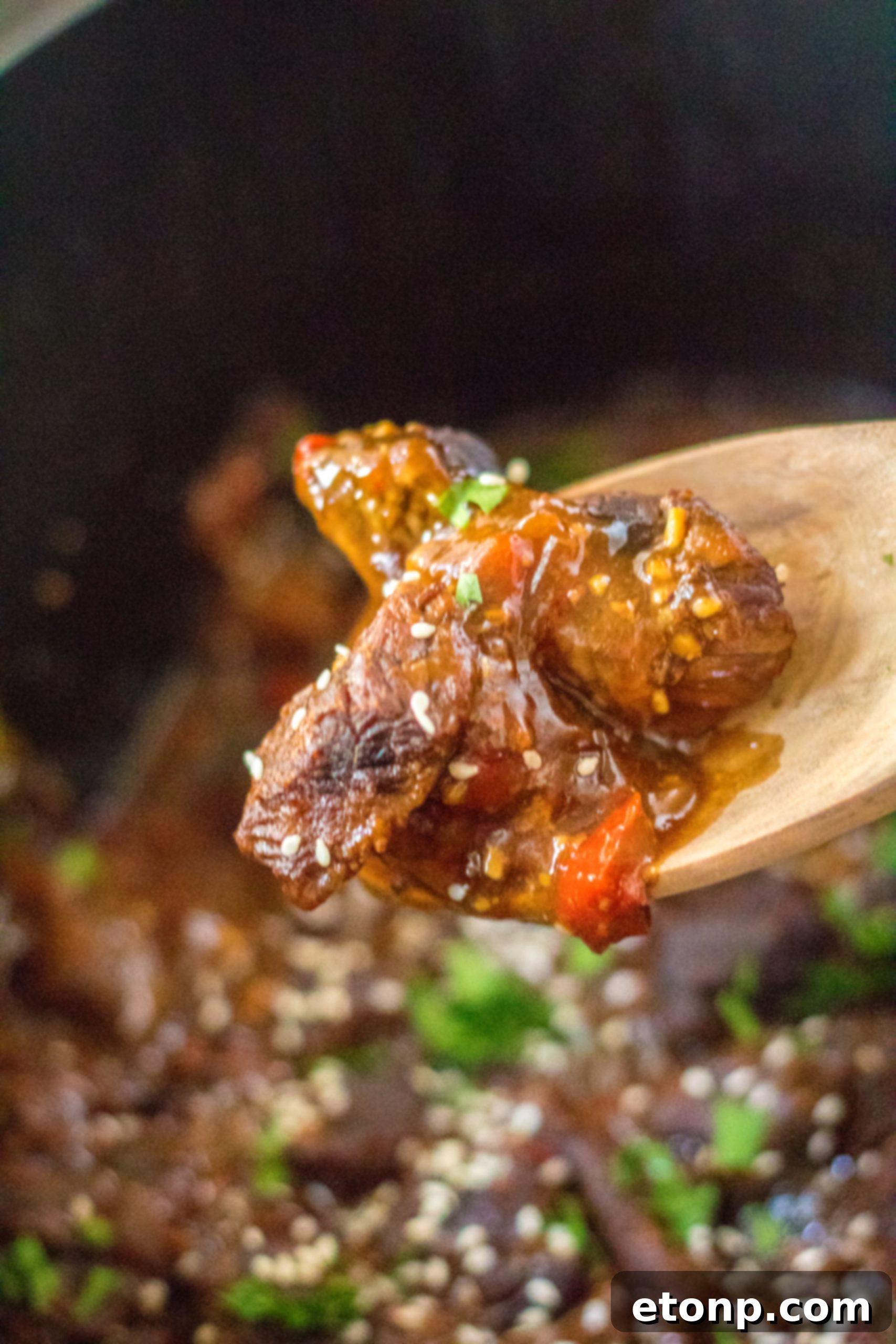 A bowl of Slow Cooker Pepper Steak and Onions with rice and a garnish of sesame seeds.