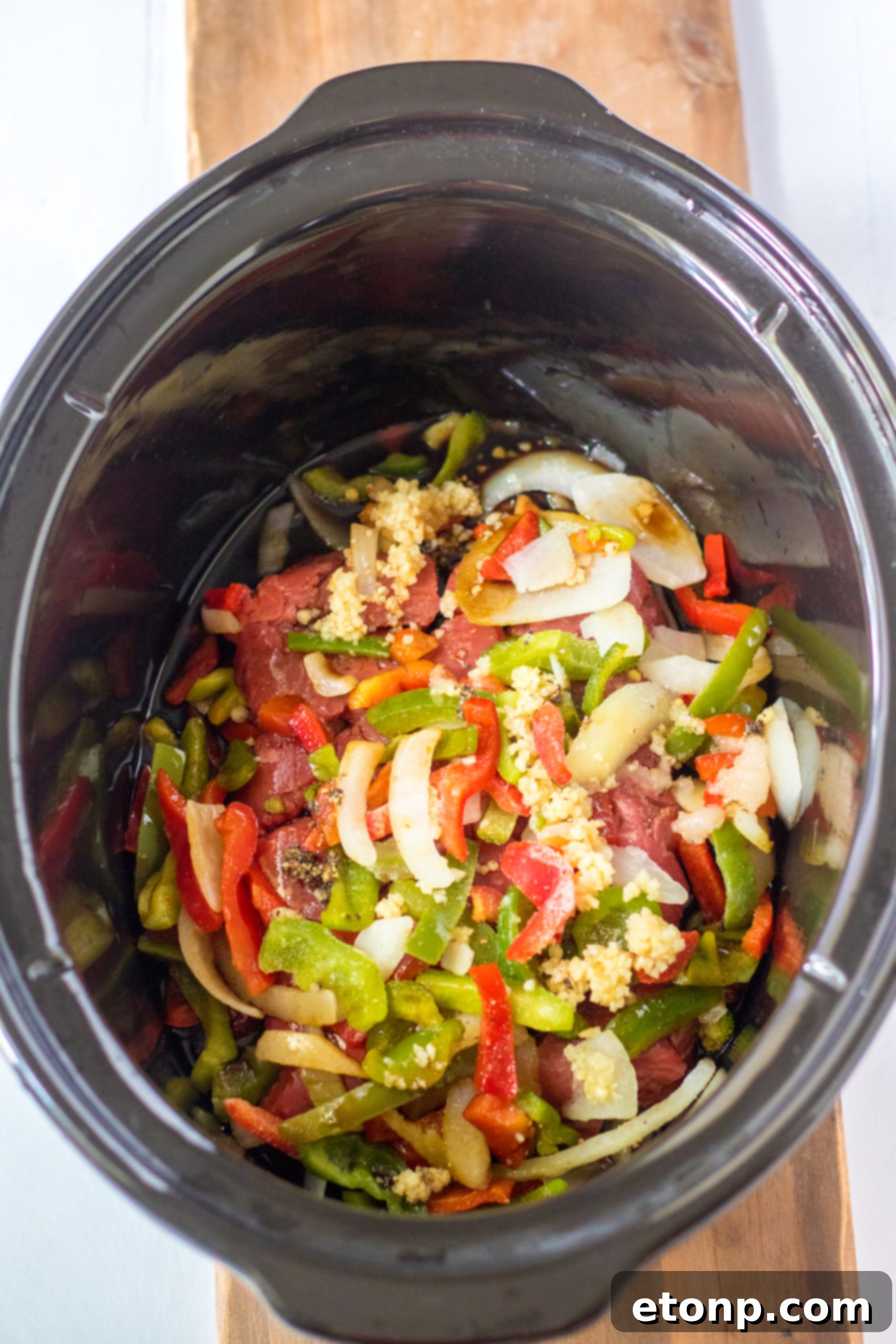 A close-up of the Slow Cooker Pepper Steak cooking in the crockpot.