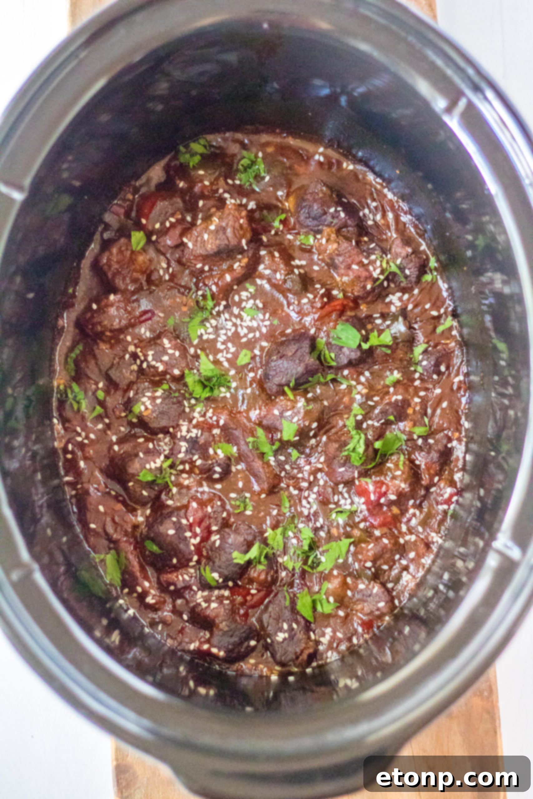 Slow Cooker Pepper Steak in a serving dish, ready to be plated.
