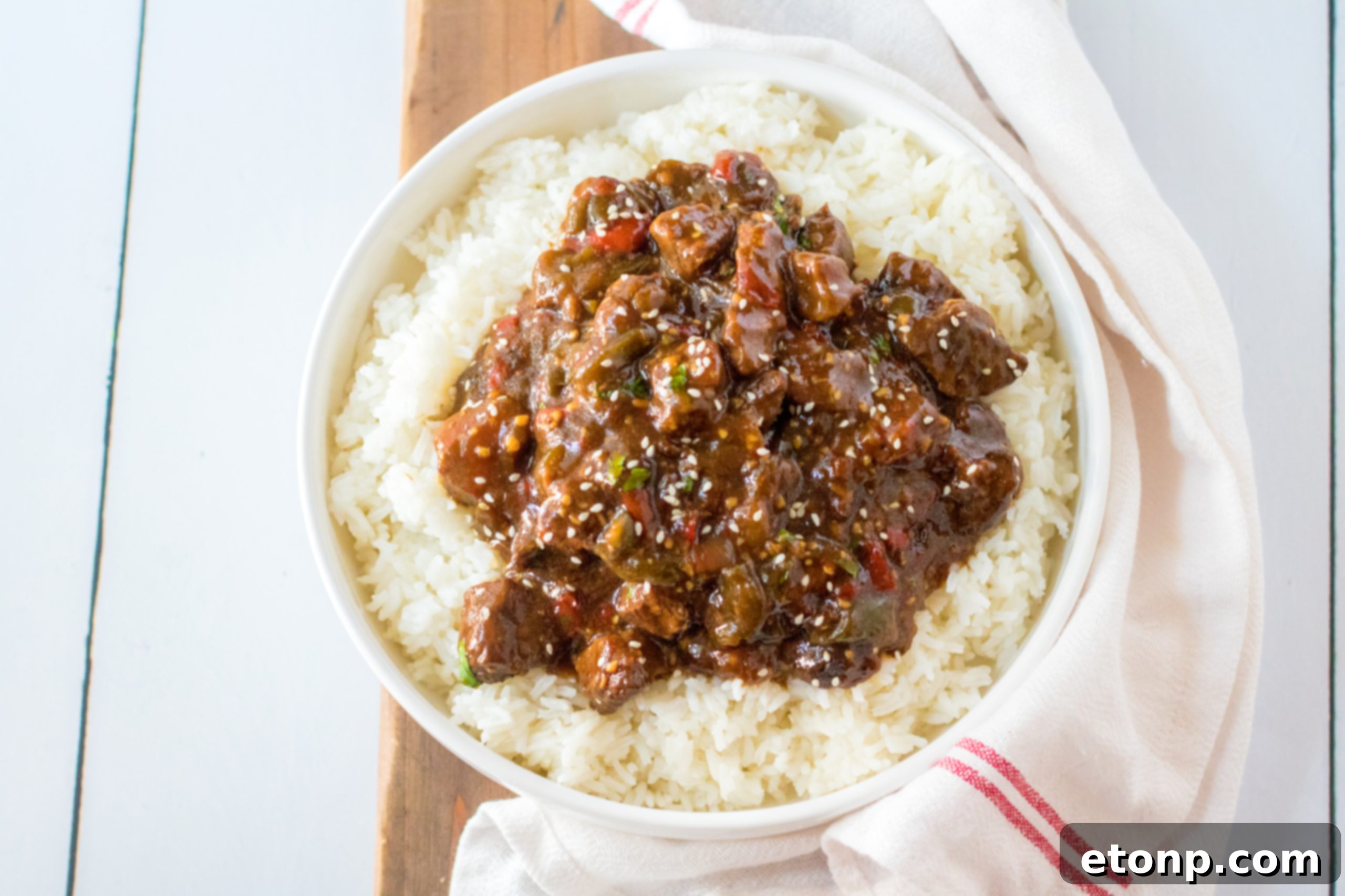 Beef and peppers simmering in a slow cooker, creating a rich sauce.