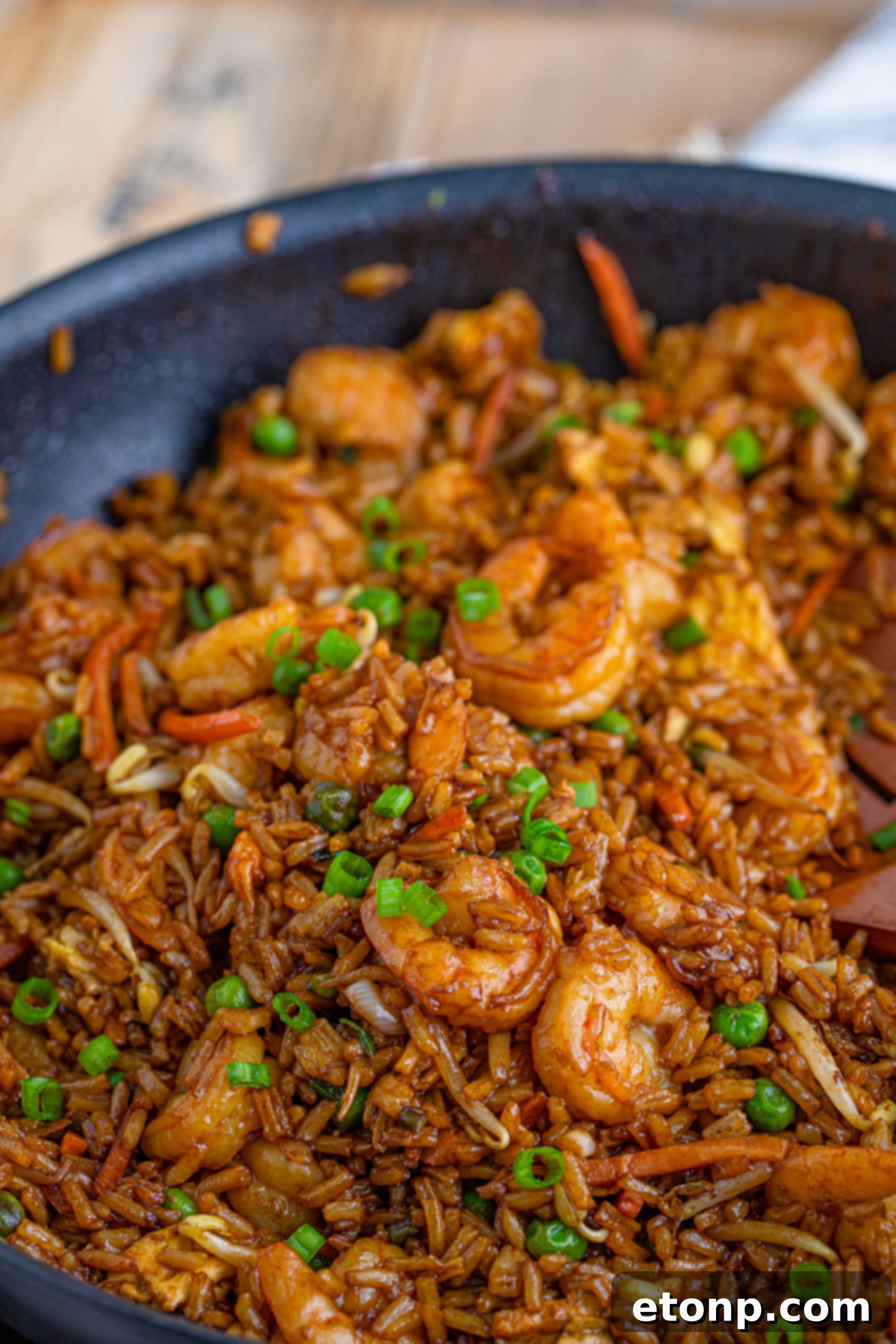 Golden Shrimp Fried Rice 5 Fresh, raw shrimp ready for preparation, next to various vegetables like carrots and peas.