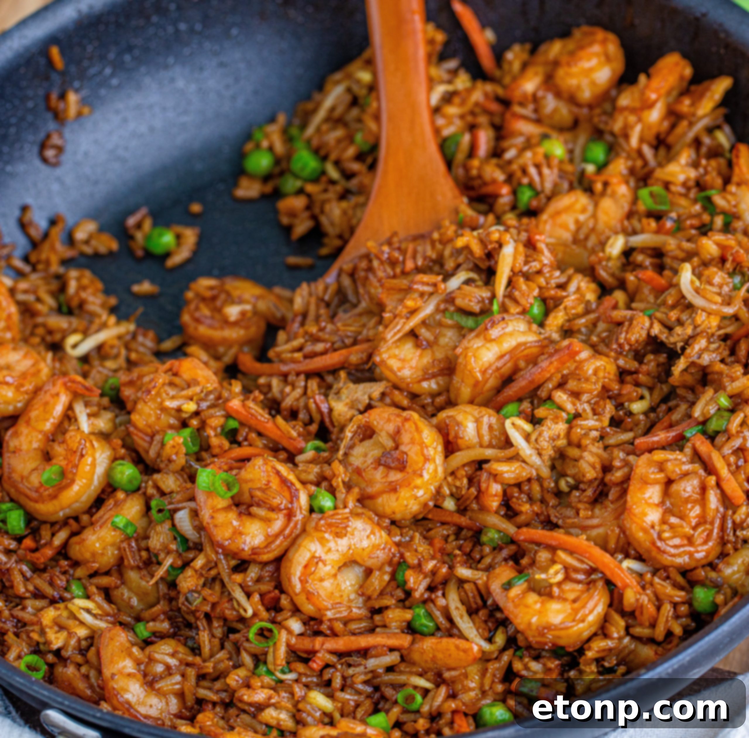 Golden Shrimp Fried Rice 9 A serving of shrimp fried rice with a fork, emphasizing its delicious texture.