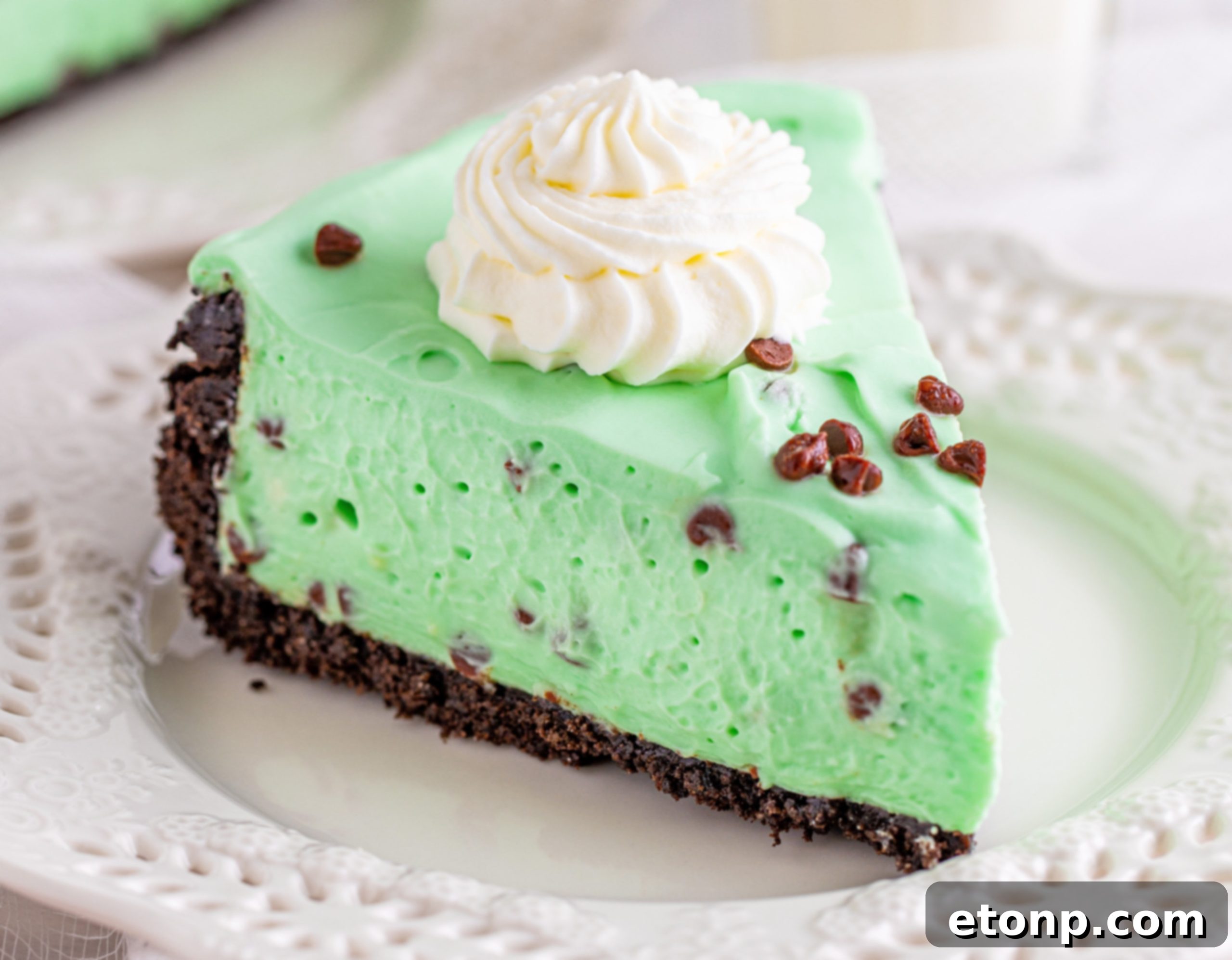 A bowl of green mint cheesecake filling with mini chocolate chips, showing the vibrant color