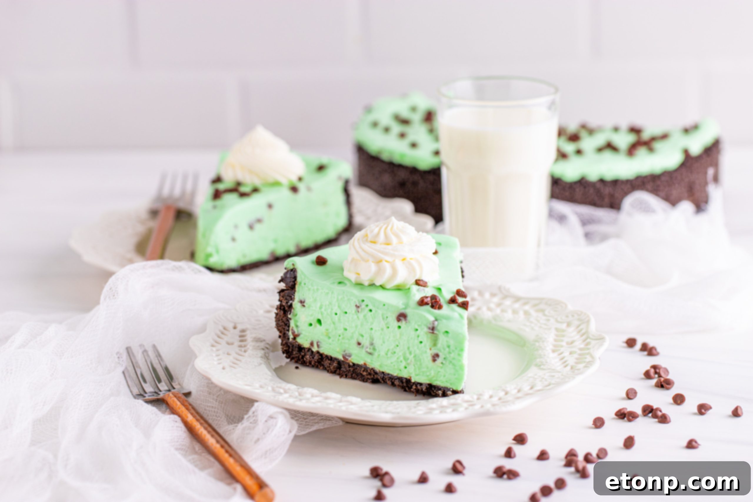 A decorated no-bake mint chocolate chip cheesecake with various toppings and garnishes
