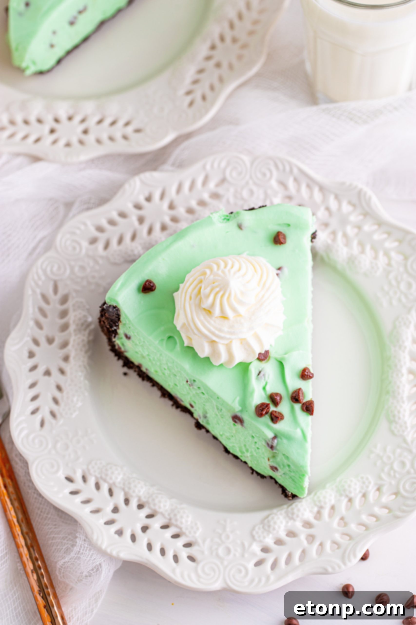 A slice of no-bake mint chocolate chip cheesecake, showcasing the layered texture of crust and filling