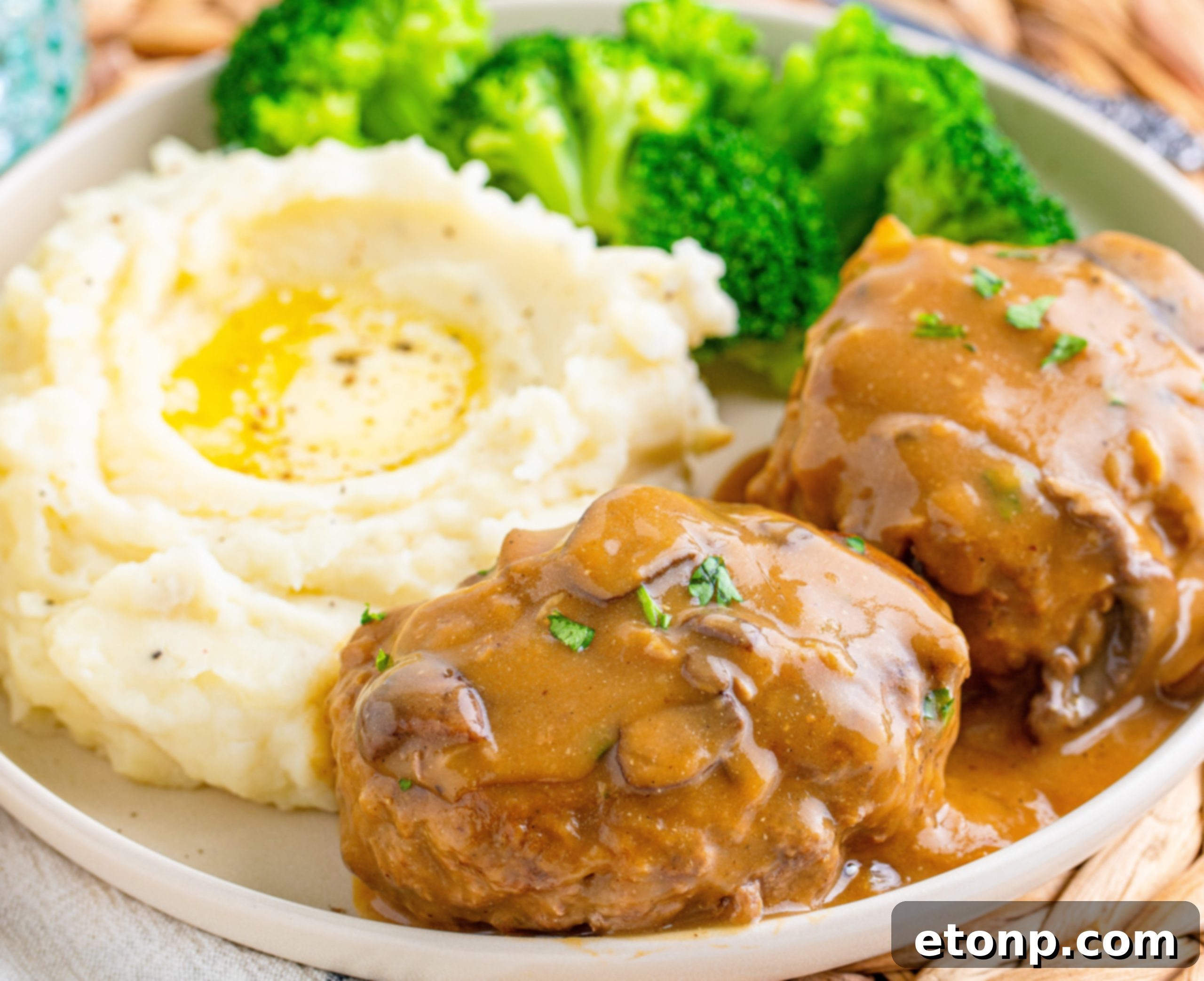 Plated Salisbury Steaks with mashed potatoes, broccoli, and gravy