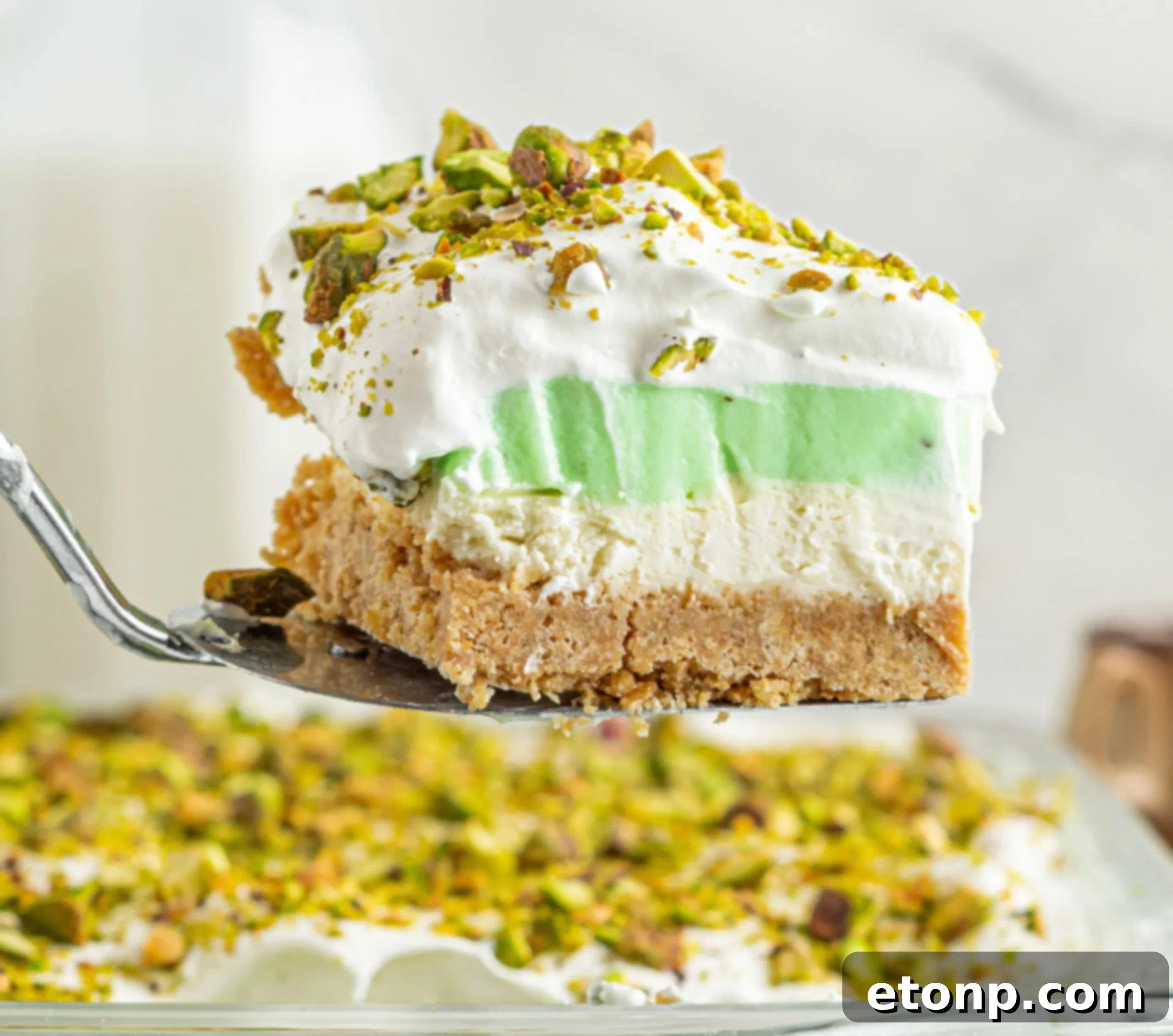 A final shot of a single slice of Pistachio Lush Dessert, showcasing its beautiful layers and inviting texture.