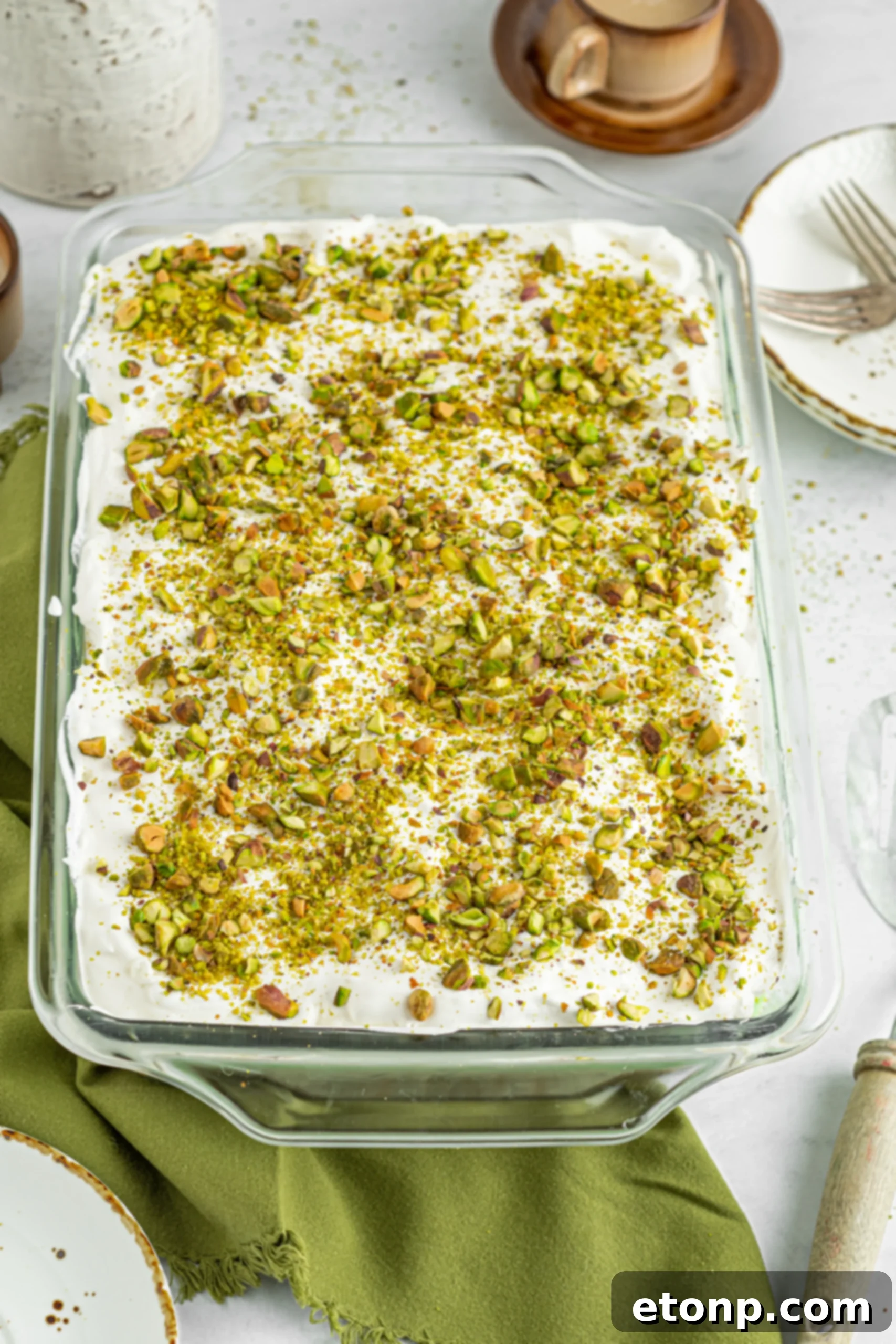 The Pistachio Lush Dessert in a clear glass baking dish, showing all four layers before being sliced.