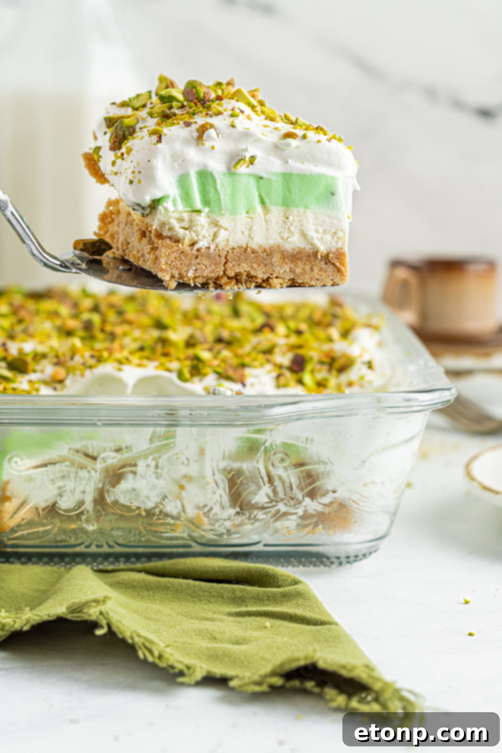 Another close-up of the Pistachio Lush Dessert, highlighting the fluffy whipped topping and vibrant green pudding layer.