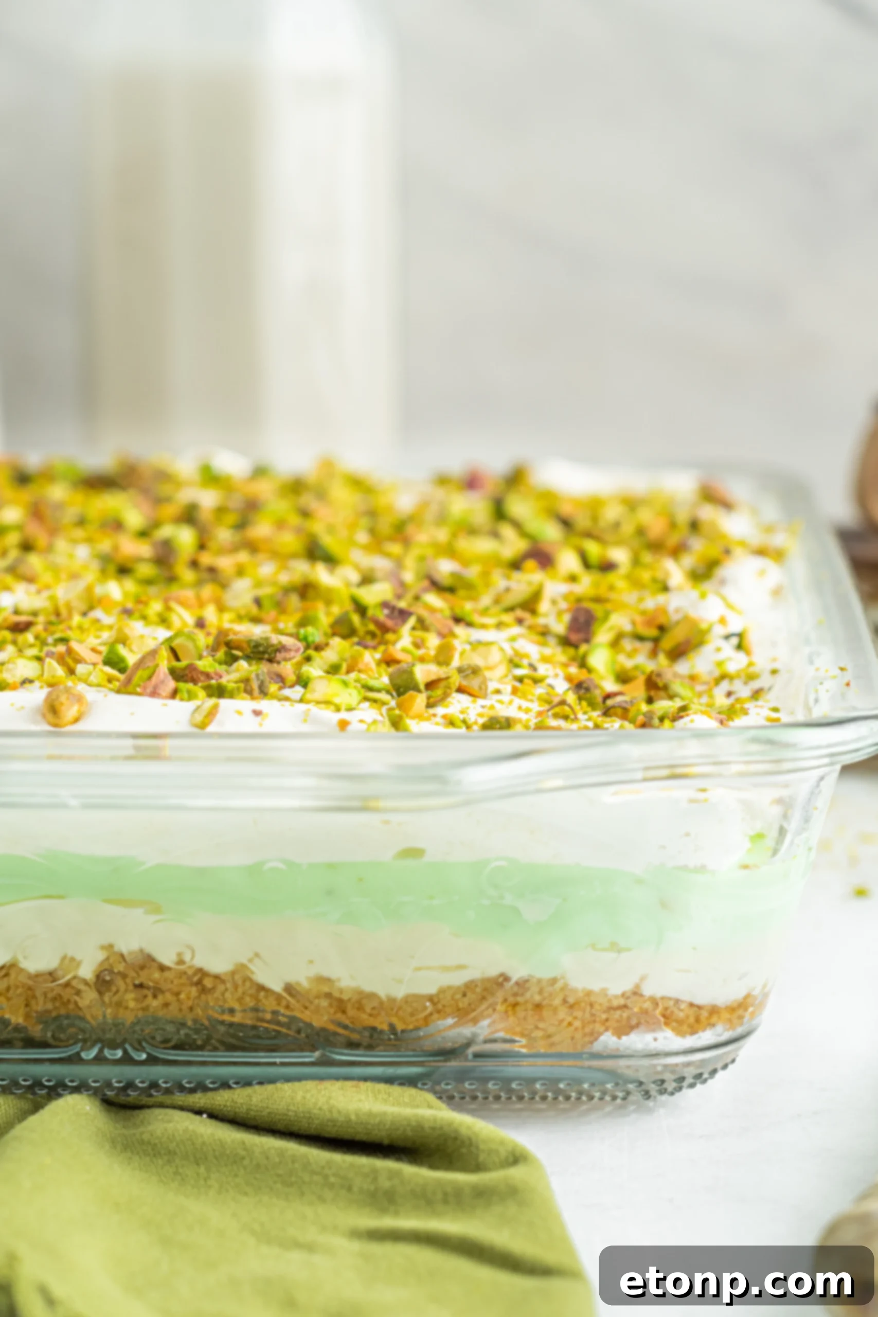 Close-up on a spoonful of Pistachio Lush Dessert, emphasizing the soft and creamy layers.