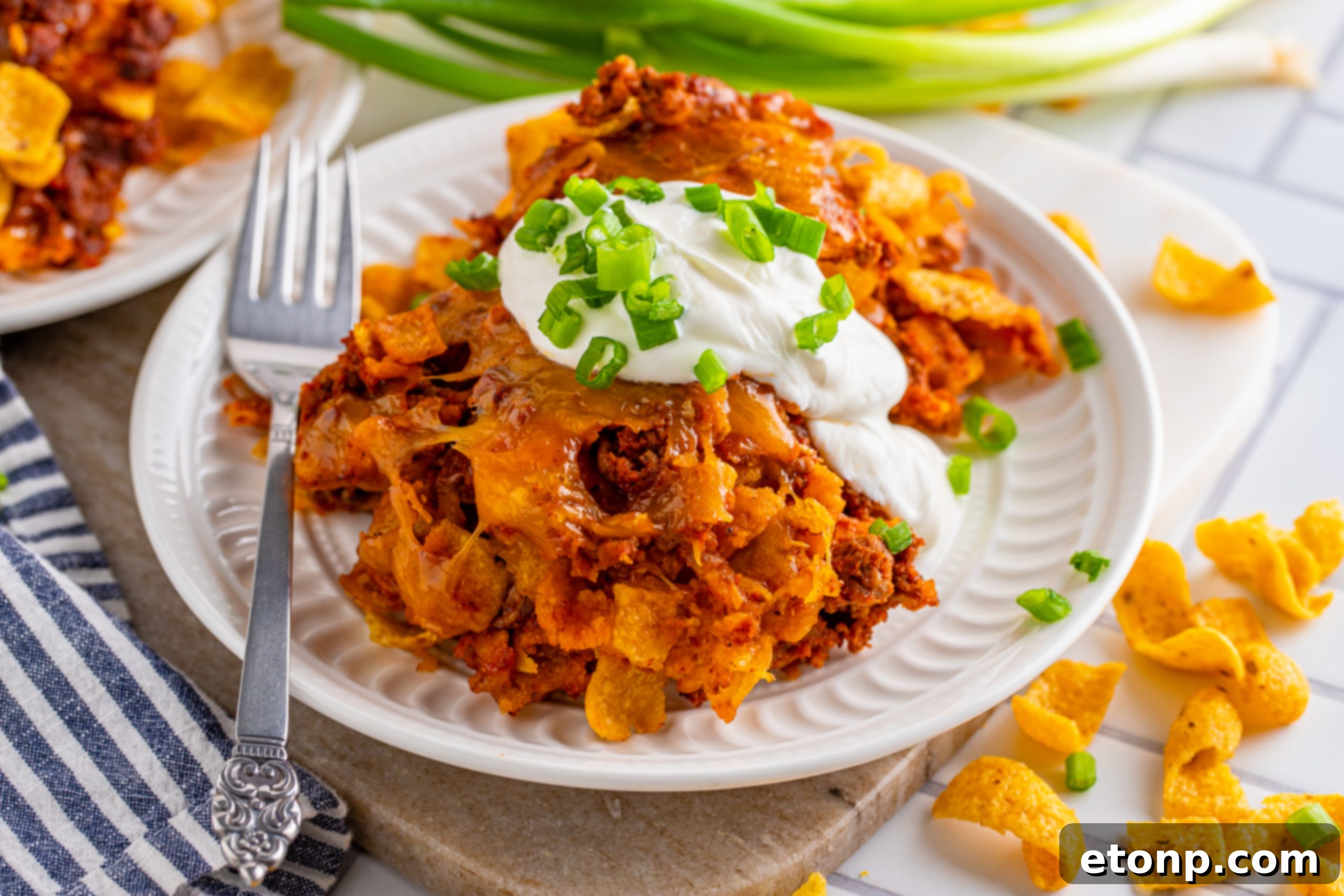 Individual serving of Cheesy Frito Chili Casserole with fresh toppings