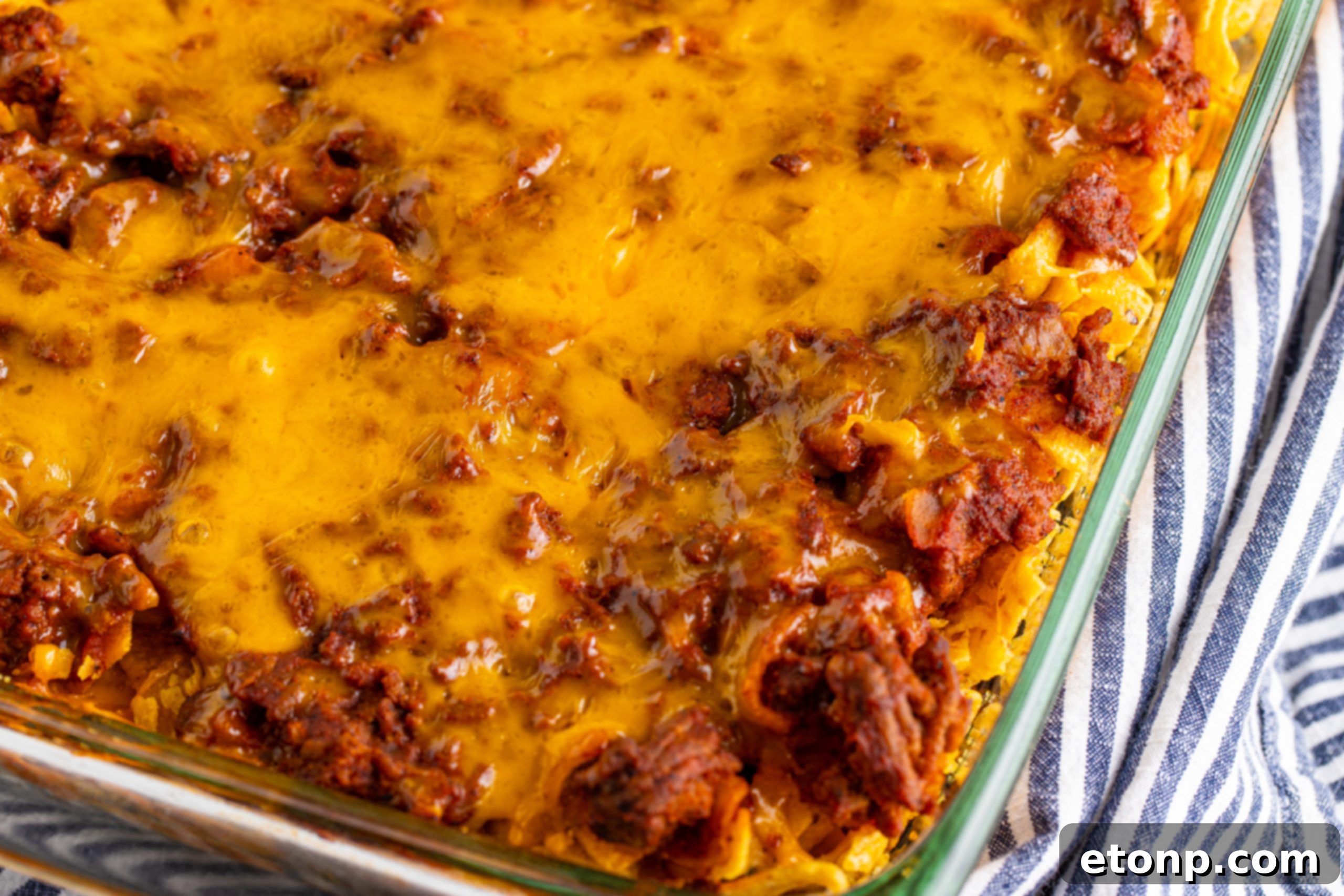 Serving of Cheesy Frito Chili Casserole with sour cream and scallions