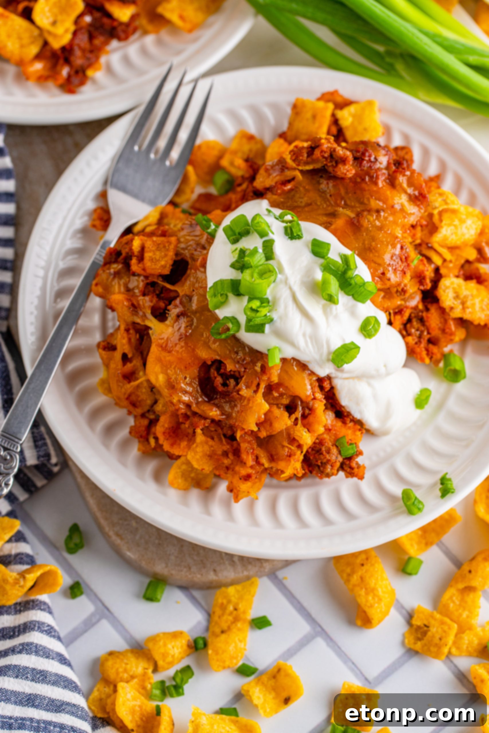 A spoon scooping a portion of Cheesy Frito Chili Casserole