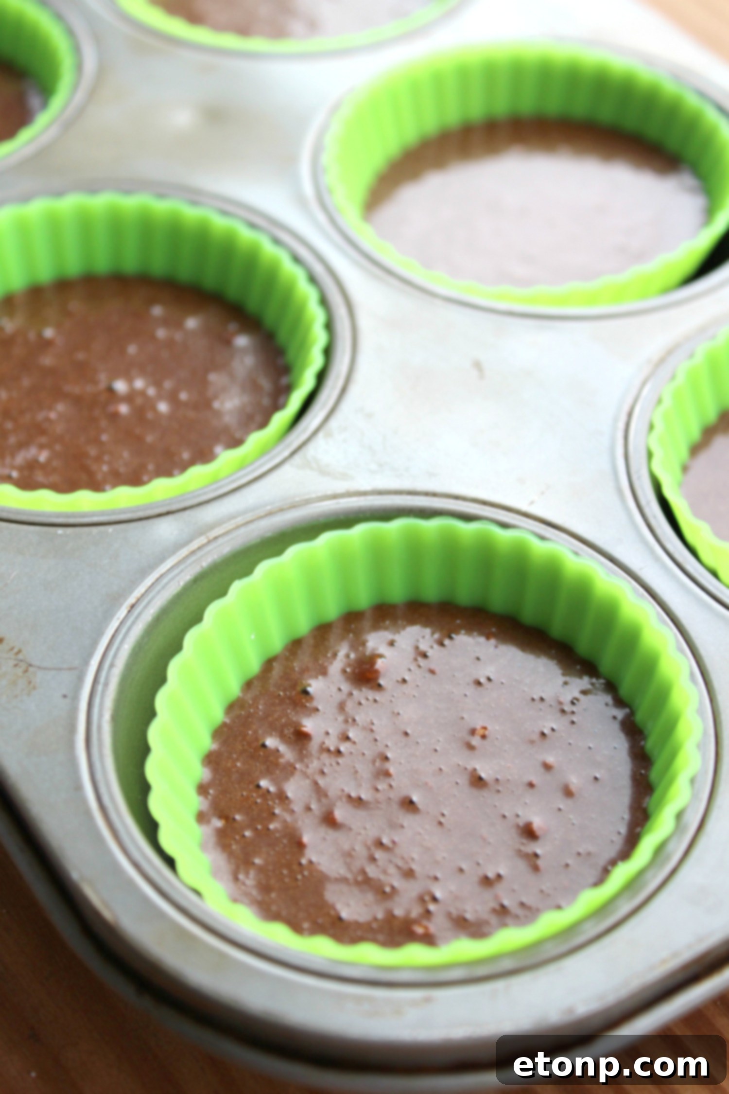 Green mint frosting being expertly piped onto a chocolate cupcake, adorned with Thin Mint cookies.