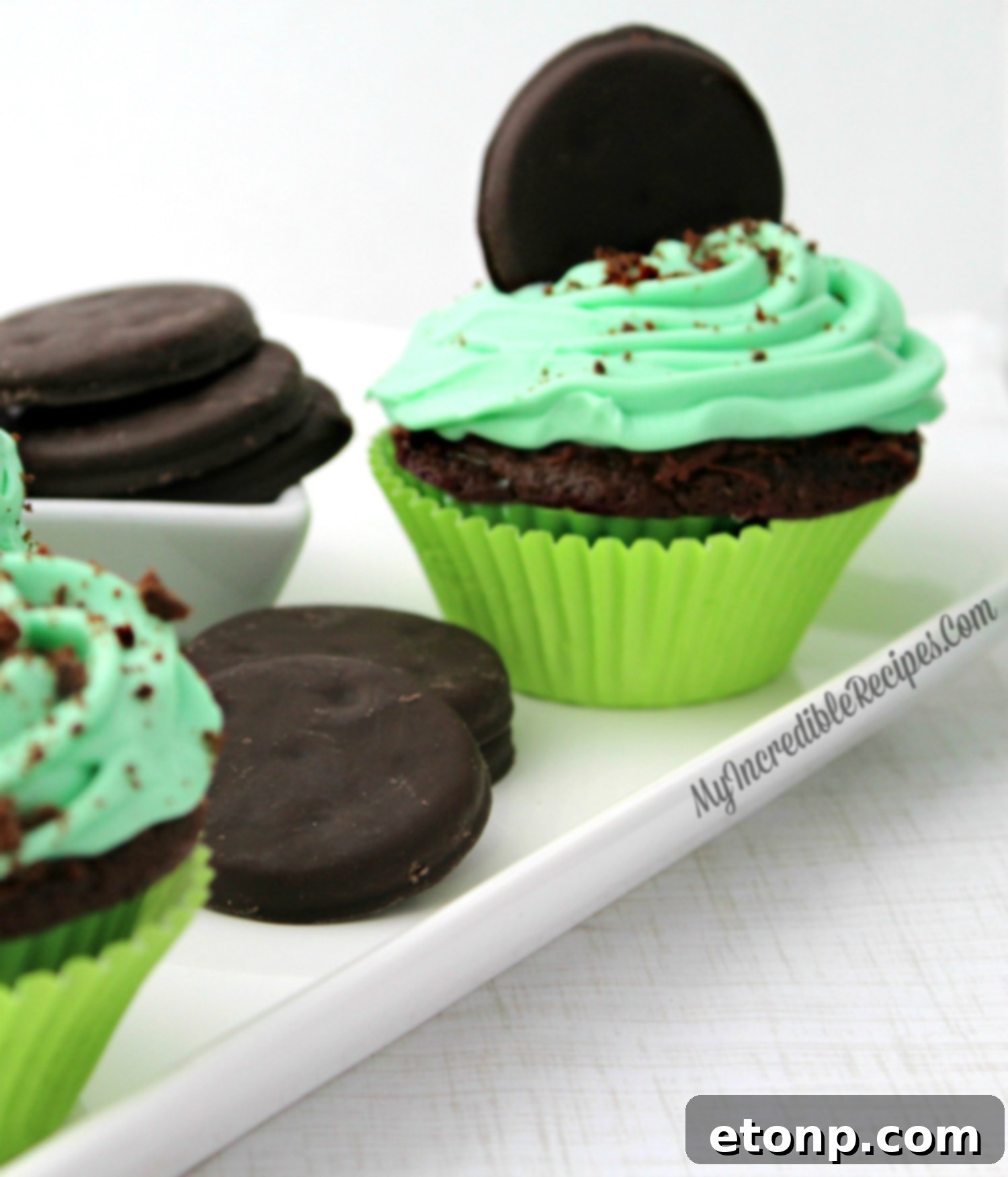 A tray filled with beautifully decorated Thin Mint cupcakes, showcasing their rich chocolate and minty green colors.