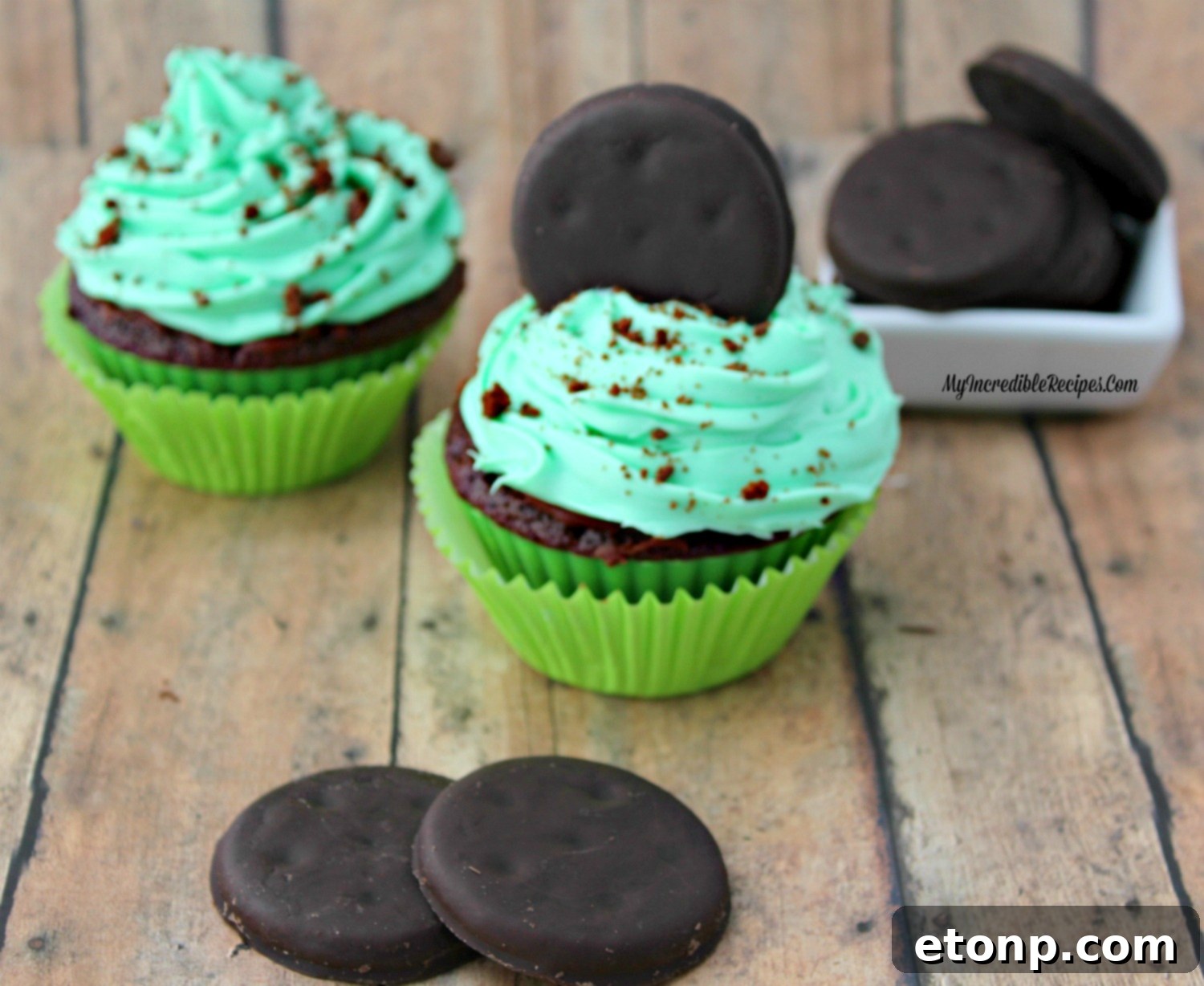 Detailed shot of the vibrant green mint frosting being elegantly piped onto a cupcake, highlighting its creamy texture.
