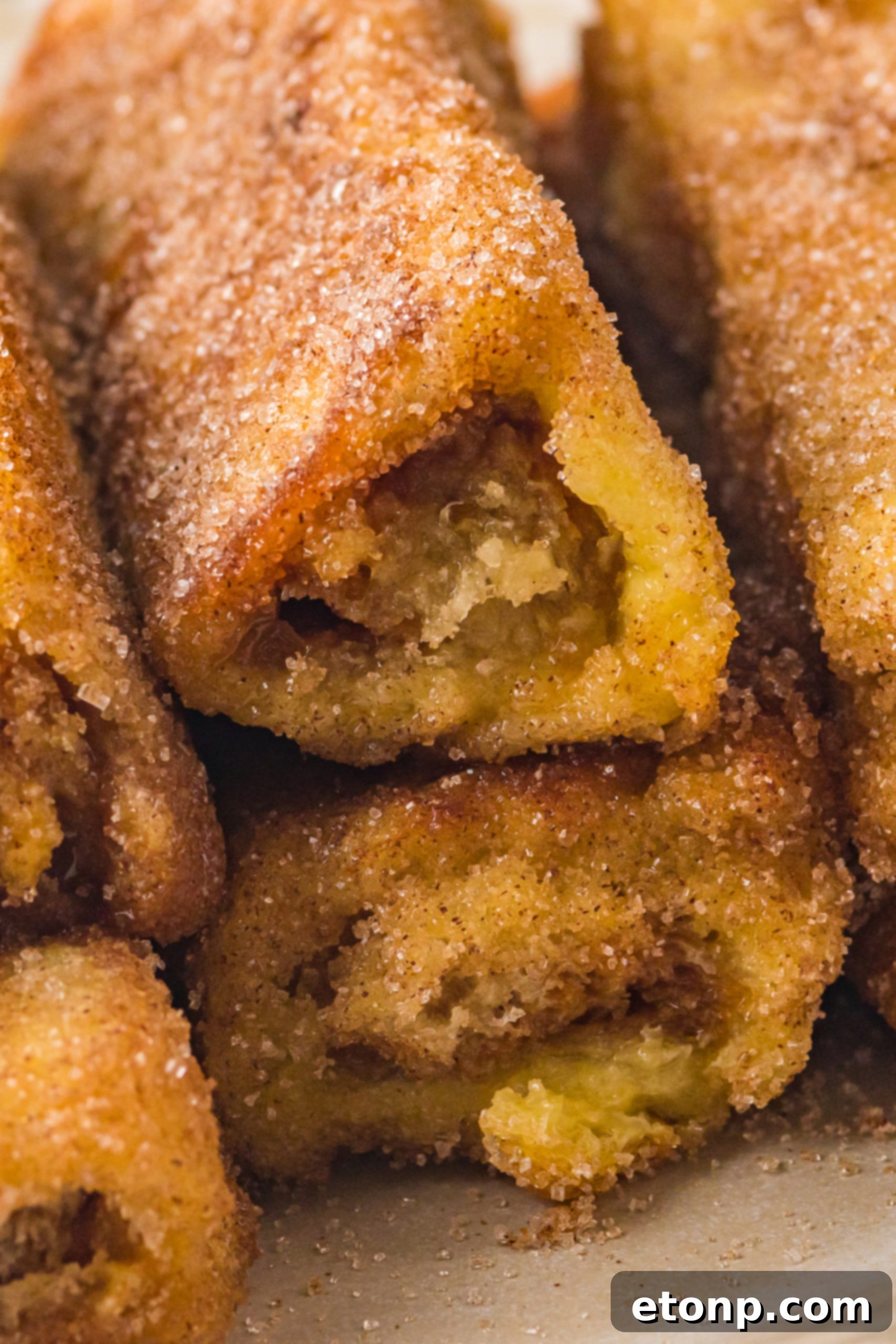 Churro French Toast Roll Ups stacked on a plate