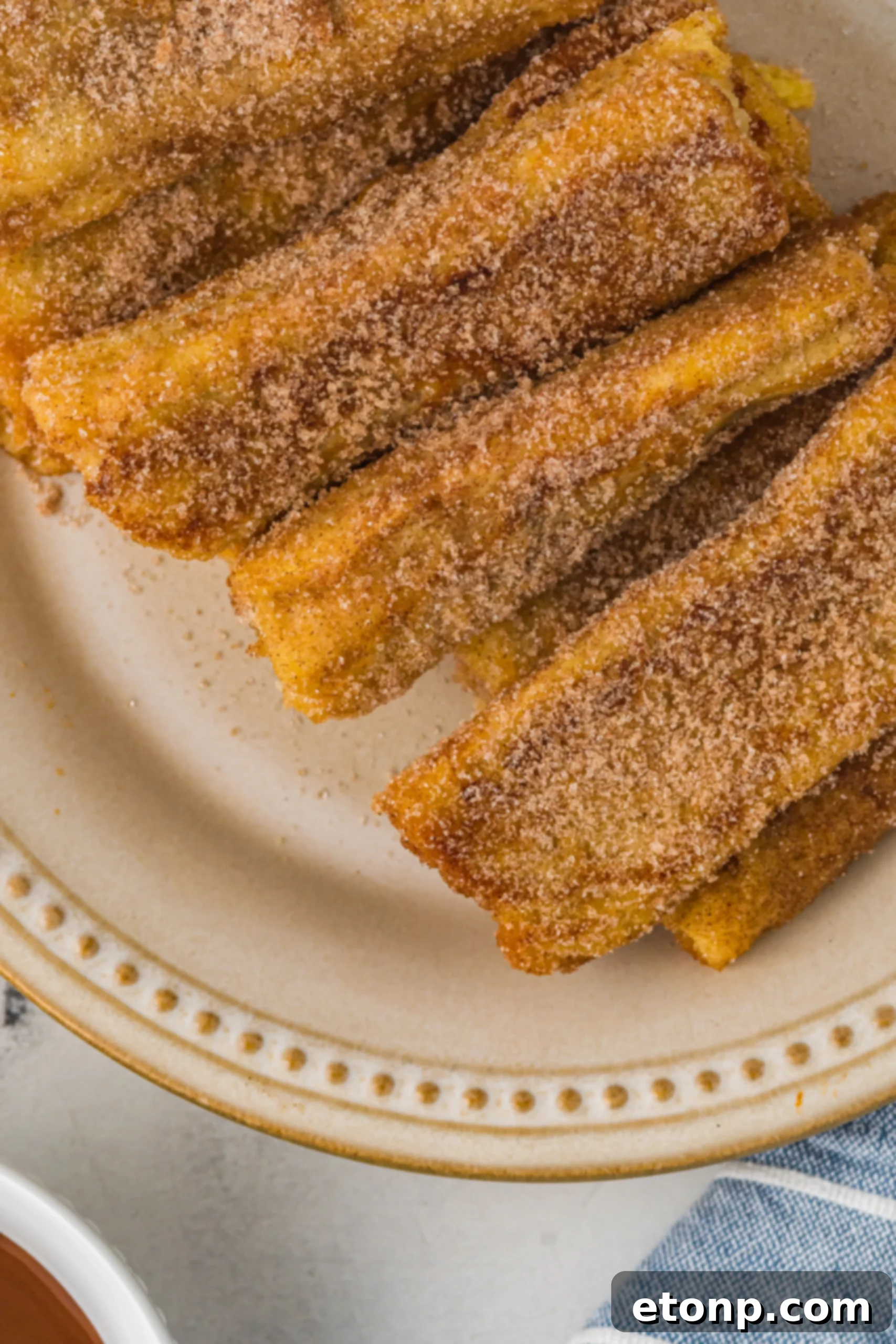 Close up of a Churro French Toast Roll Up with a caramel swirl