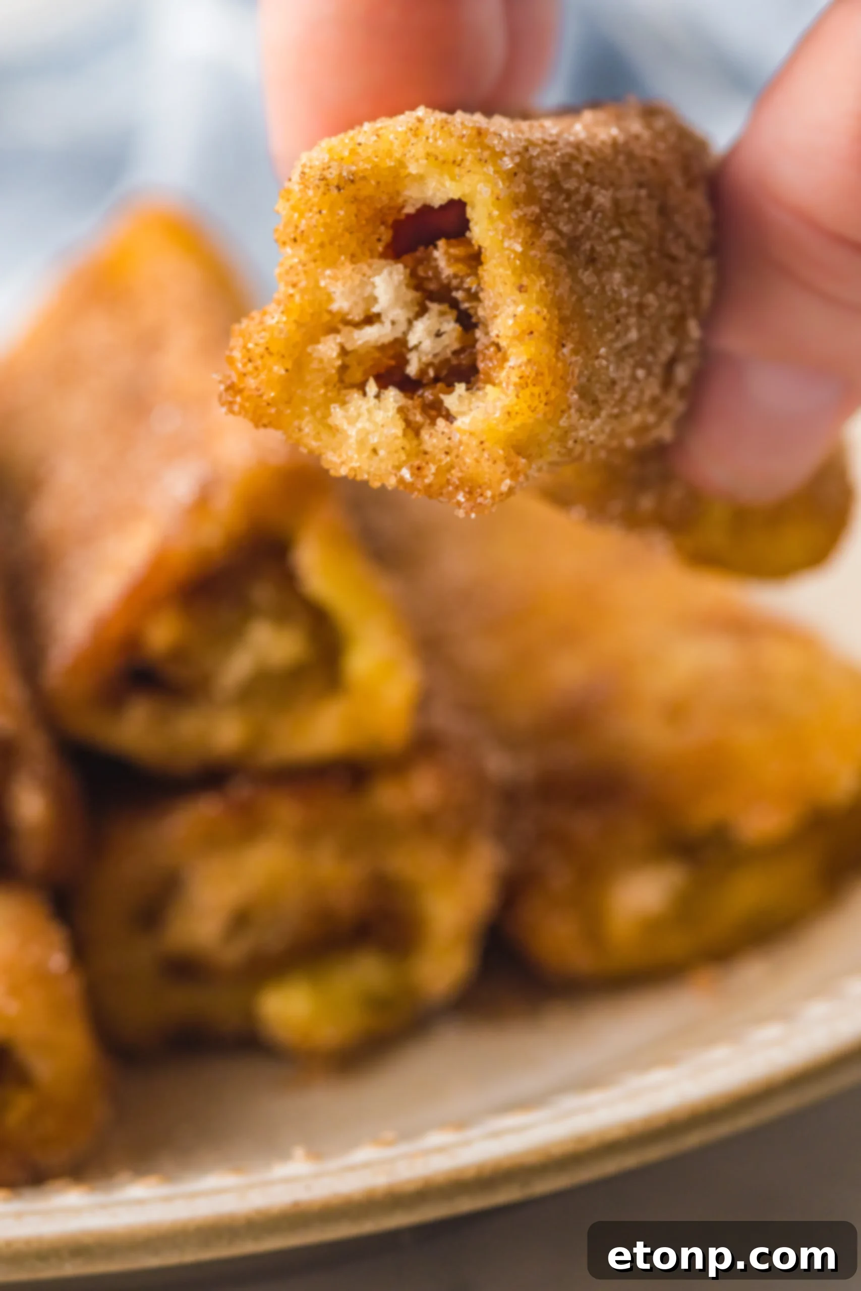 Churro French Toast Roll Ups with a bite taken