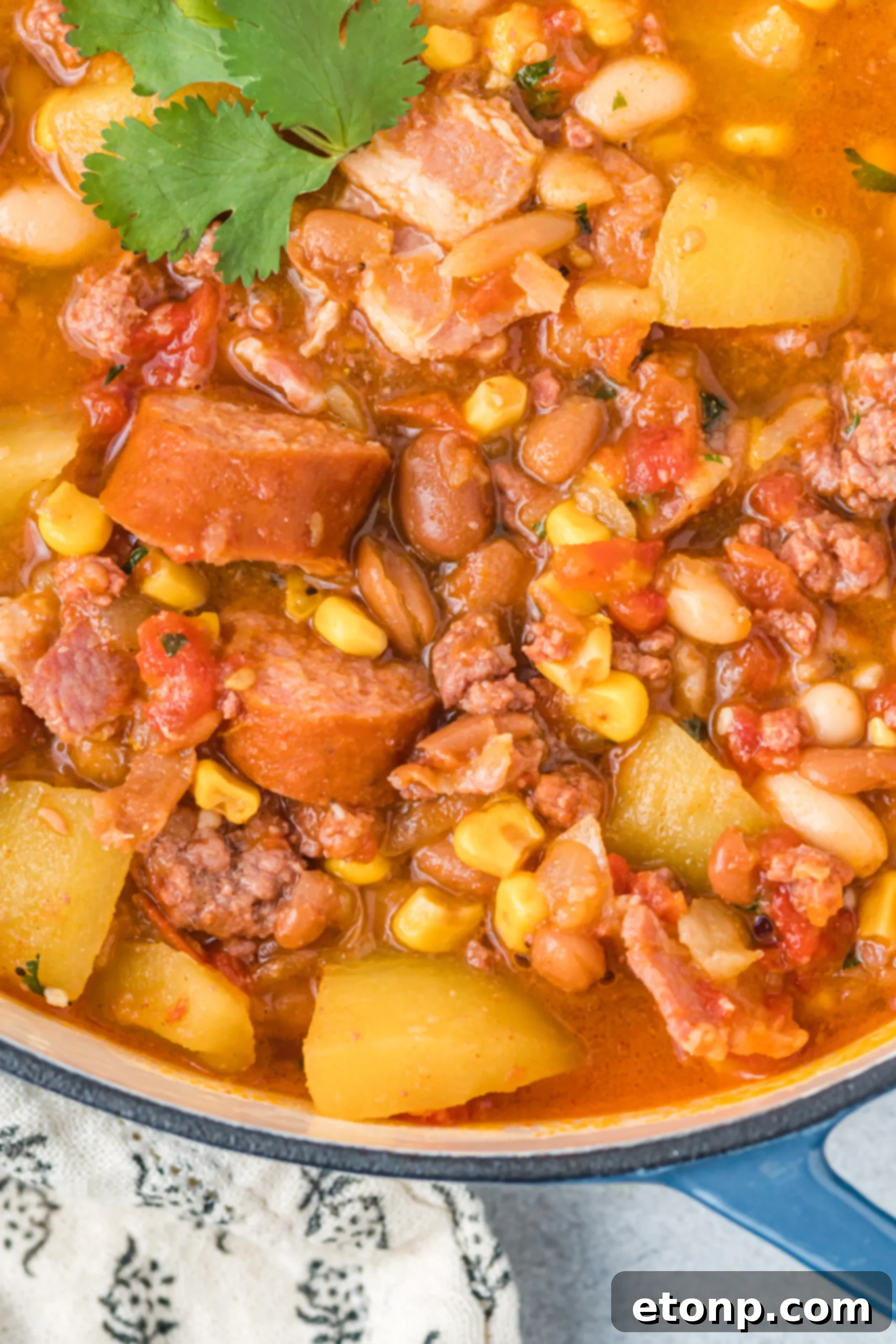 Wrangler's Frontier Stew 4 Overhead shot of a pot of simmering Cowboy Stew on a stovetop, highlighting the fresh ingredients.