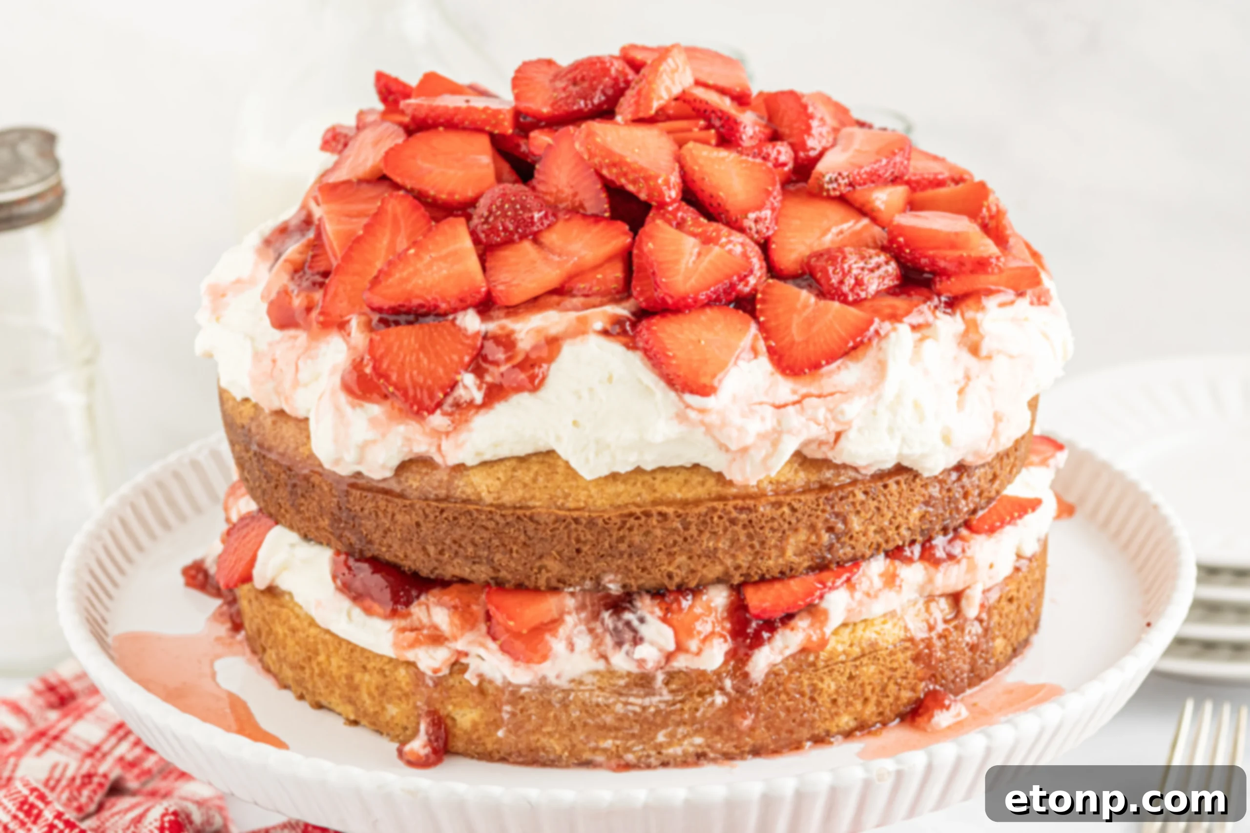 A close-up shot of the finished Strawberry Whipped Cream Cake, showcasing its beautiful layers.