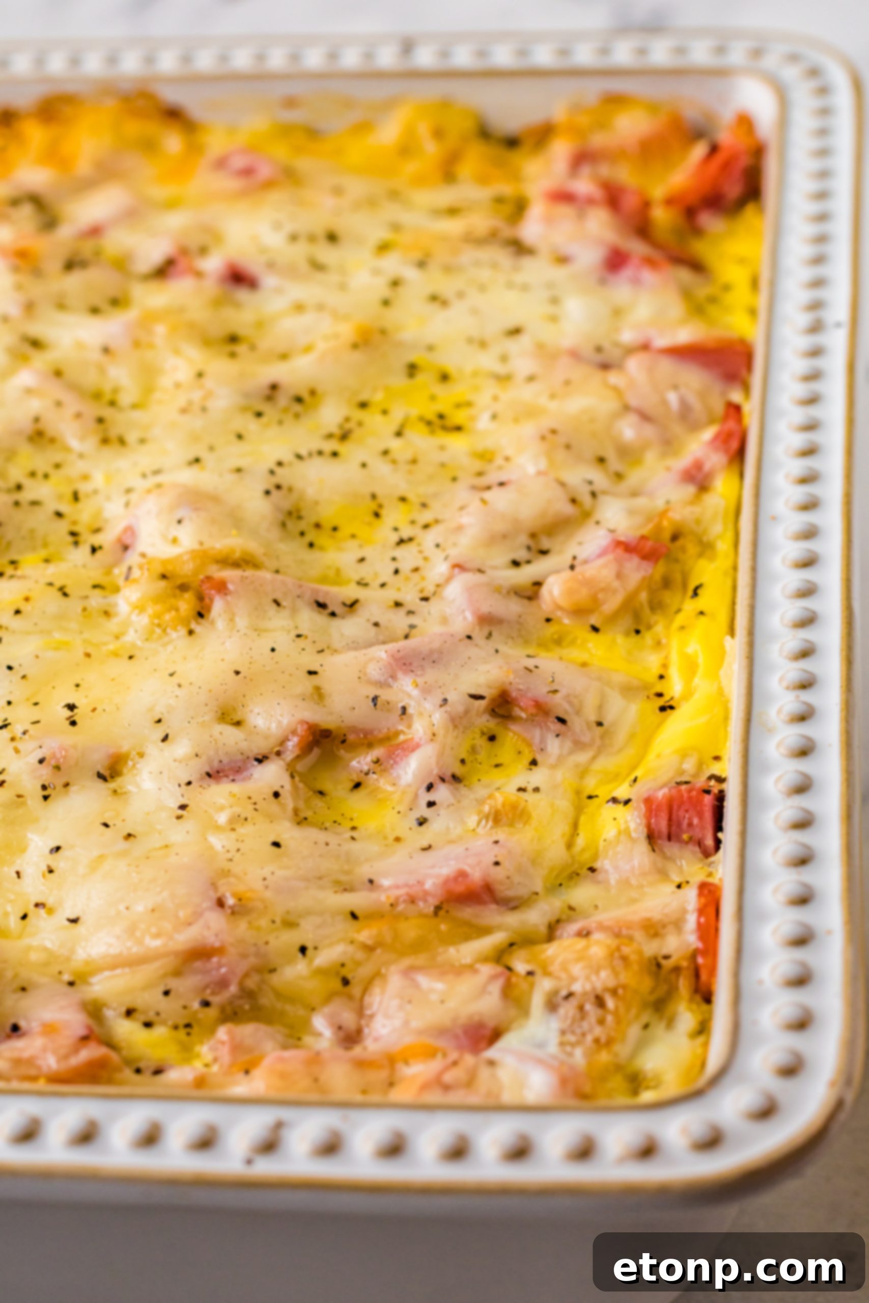 Eggs Benedict in a white casserole dish up close