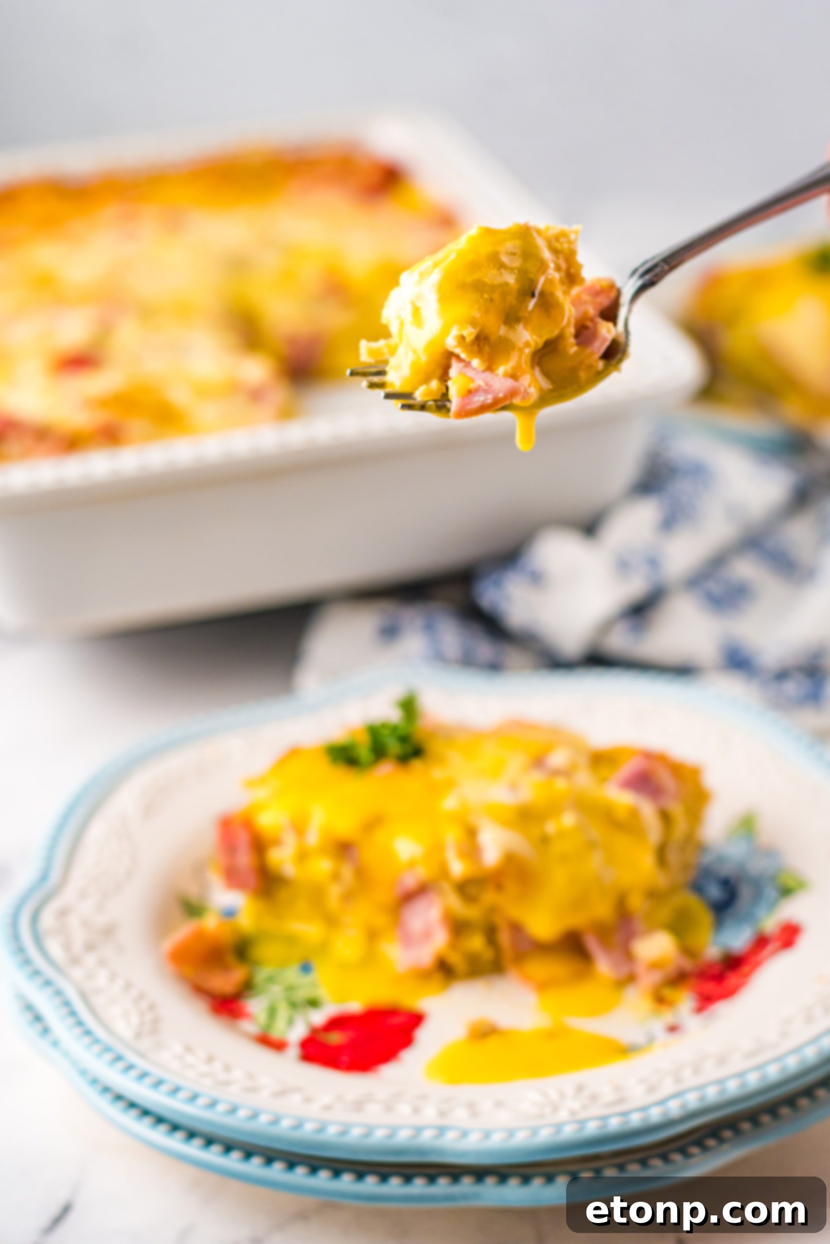 Eggs Benedict bite being shown on a fork
