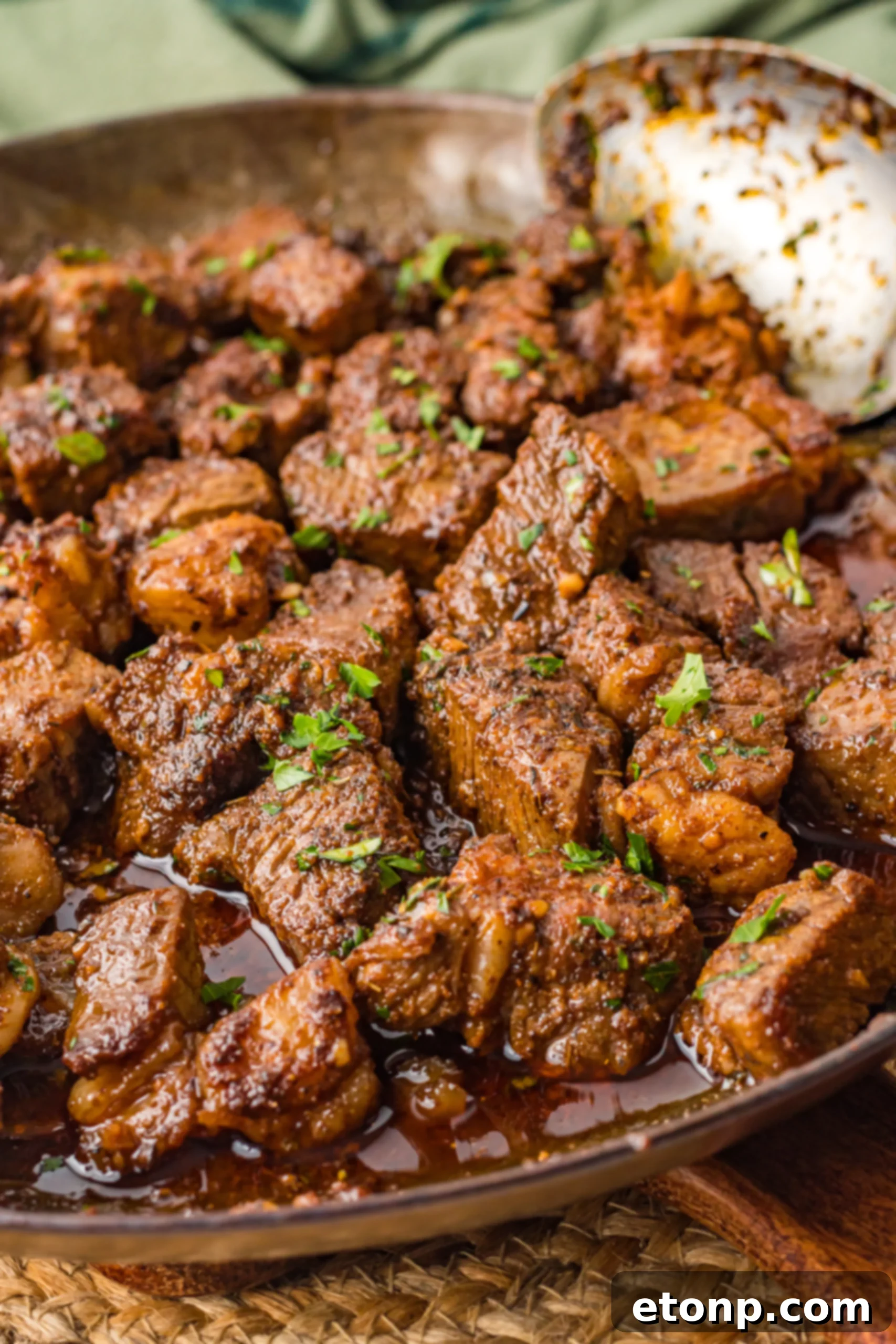 Savory Garlic Butter Steak Morsels 2 Perfectly seared Cajun Garlic Butter Steak Bites on a skillet