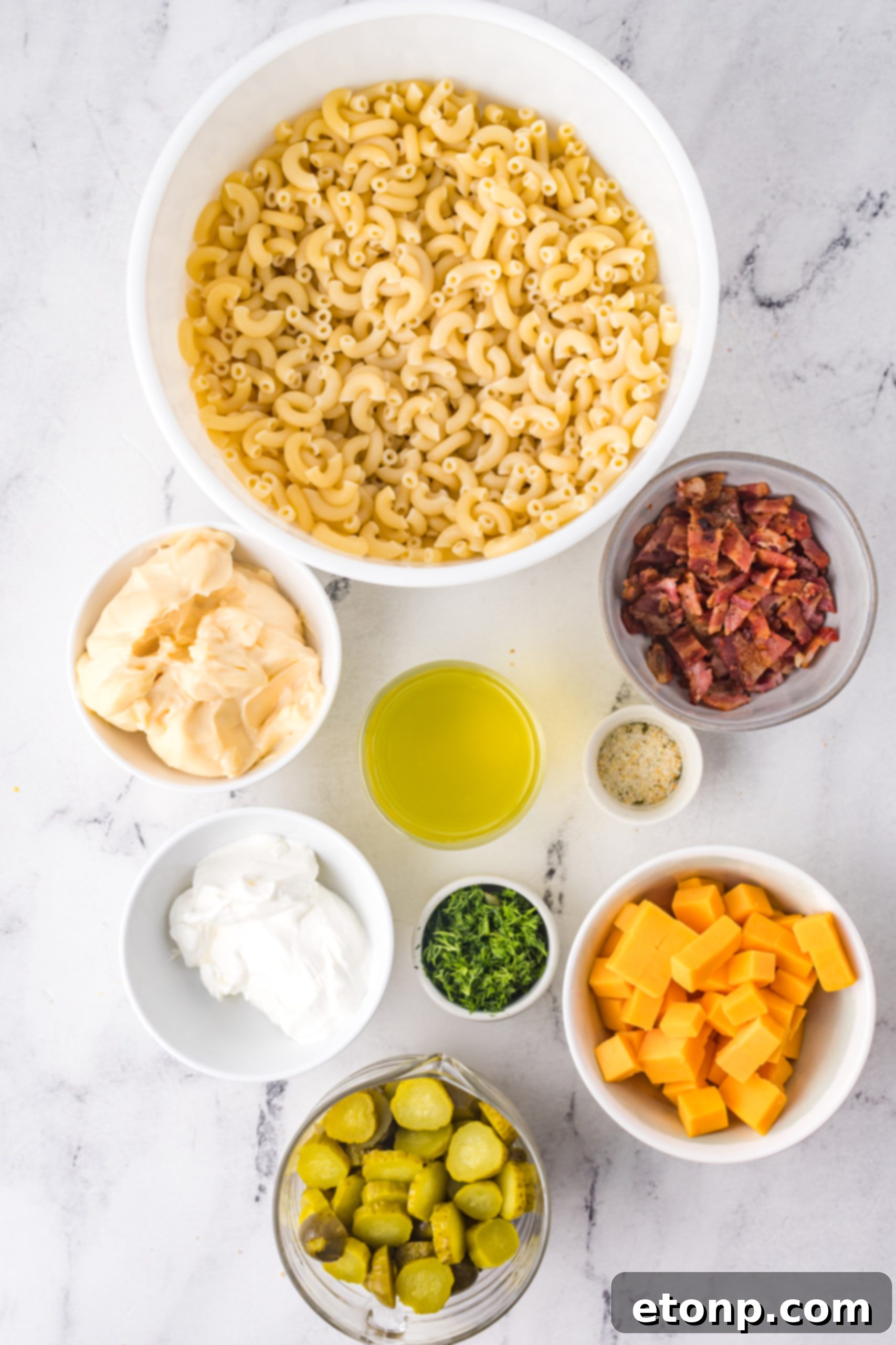 Overhead shot of a Dill Pickle Pasta Salad in a white bowl, garnished with fresh dill.