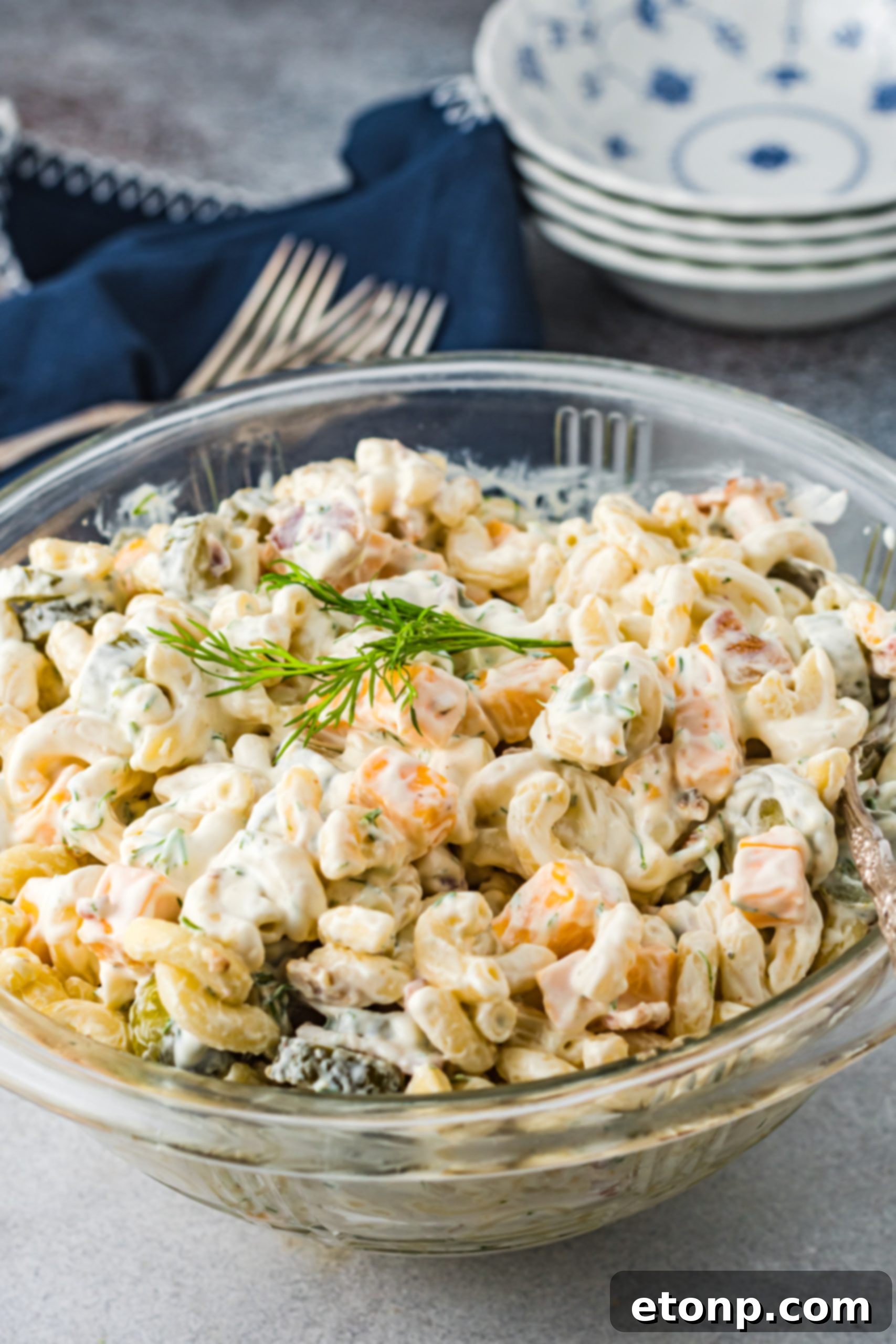 A beautifully presented bowl of Dill Pickle Pasta Salad with focus on its texture and fresh ingredients.