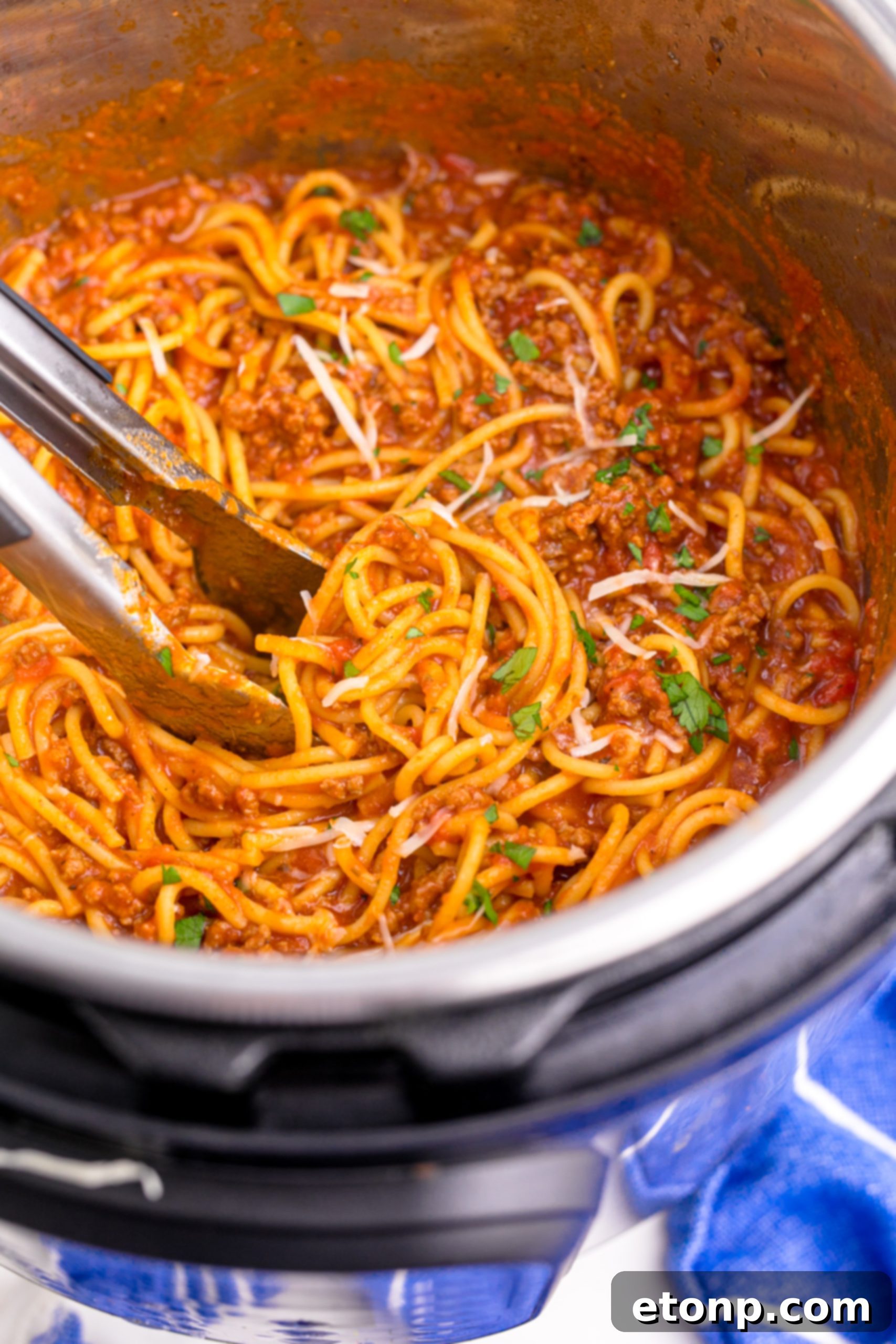 One-Pot Instant Pot Spaghetti 2 Instant Pot Spaghetti being mixed with tongs, topped with parmesan cheese, in an Instant Pot