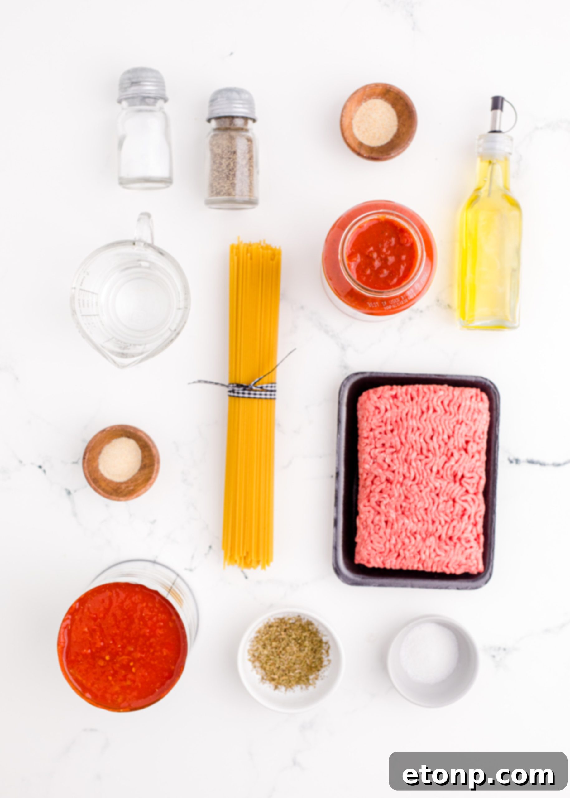 One-Pot Instant Pot Spaghetti 3 Ingredients for Instant Pot Spaghetti, including ground beef, pasta, and sauce, laid out on a kitchen counter
