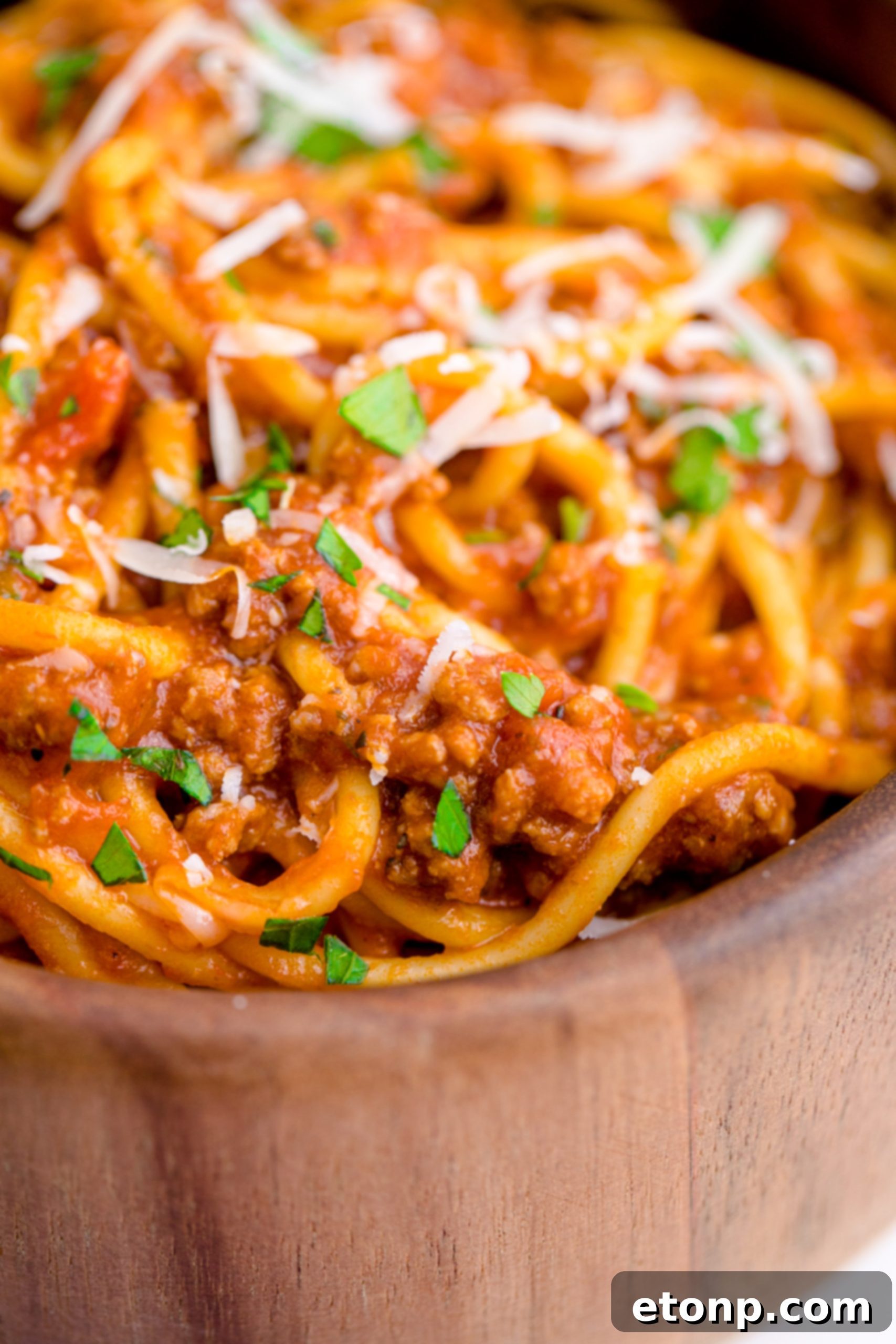 One-Pot Instant Pot Spaghetti 9 A close-up of Instant Pot Spaghetti in a wooden bowl, emphasizing its texture and rich sauce