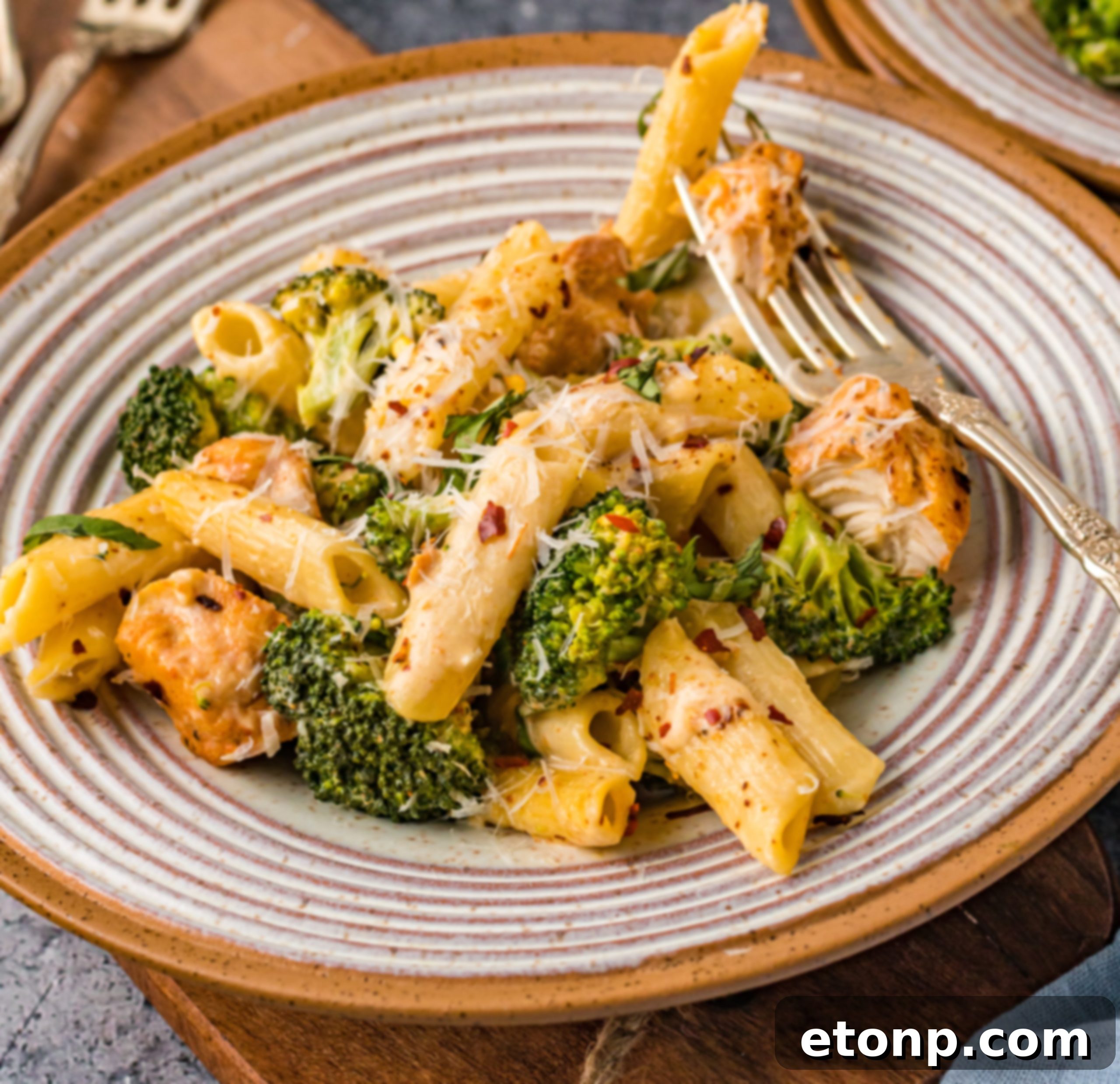 Chicken Pasta Delight 7 A dish of creamy chicken pasta on a plate with broccoli, ready to be served.