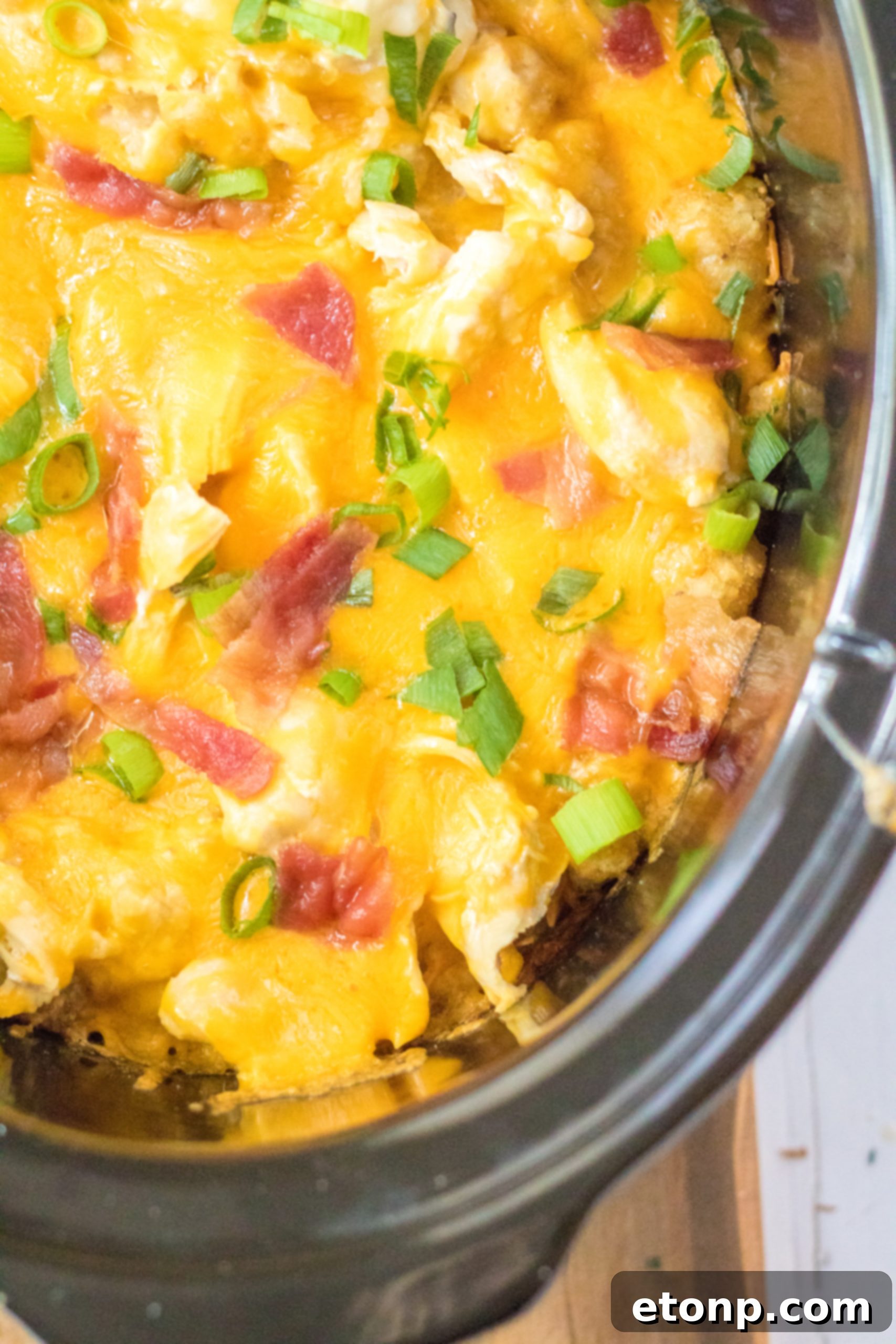 Tater Tot Casserole in the crock pot covered in melty cheese