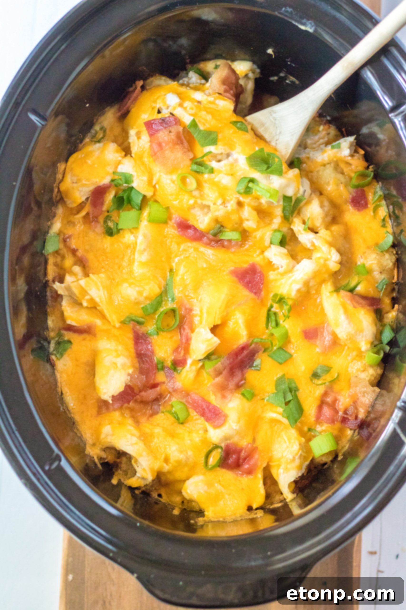 Tater Tot Casserole in the crock pot with a spoon in it