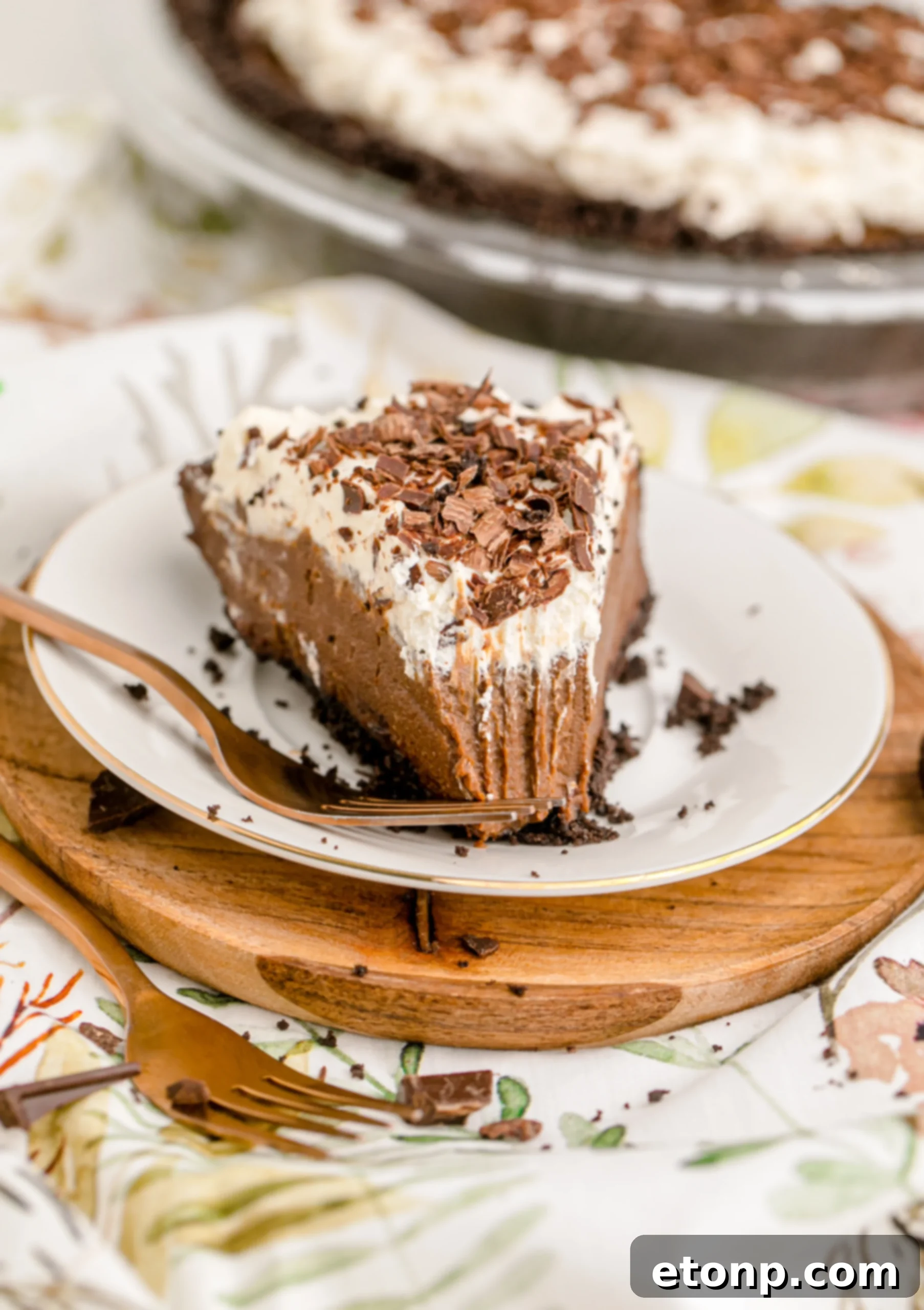 A generous slice of Chocolate Cream Pie topped with whipped cream and chocolate shavings on a white plate