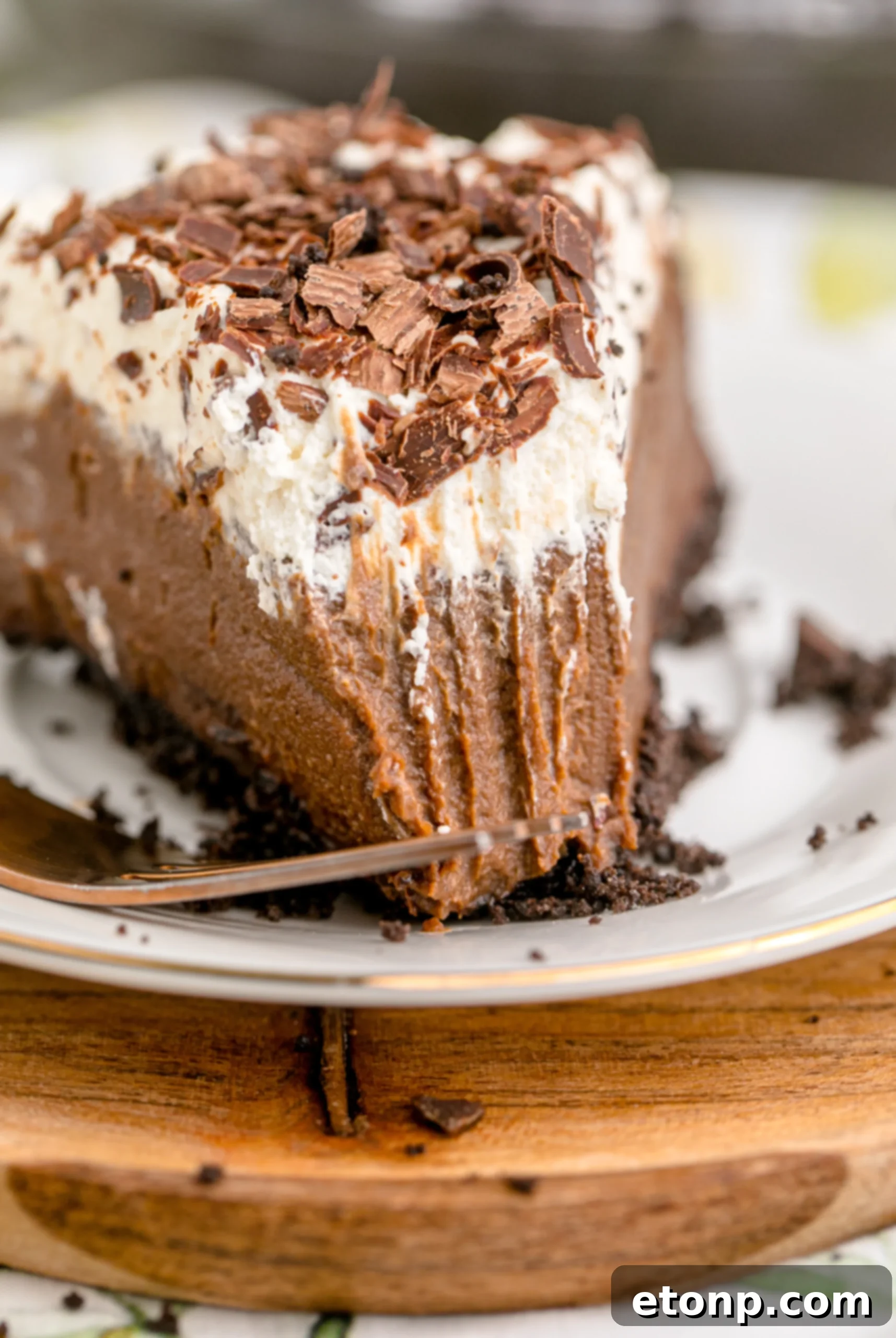 Chocolate Cream Pie topped with whipped cream and chocolate shavings on a white plate, invitingly presented