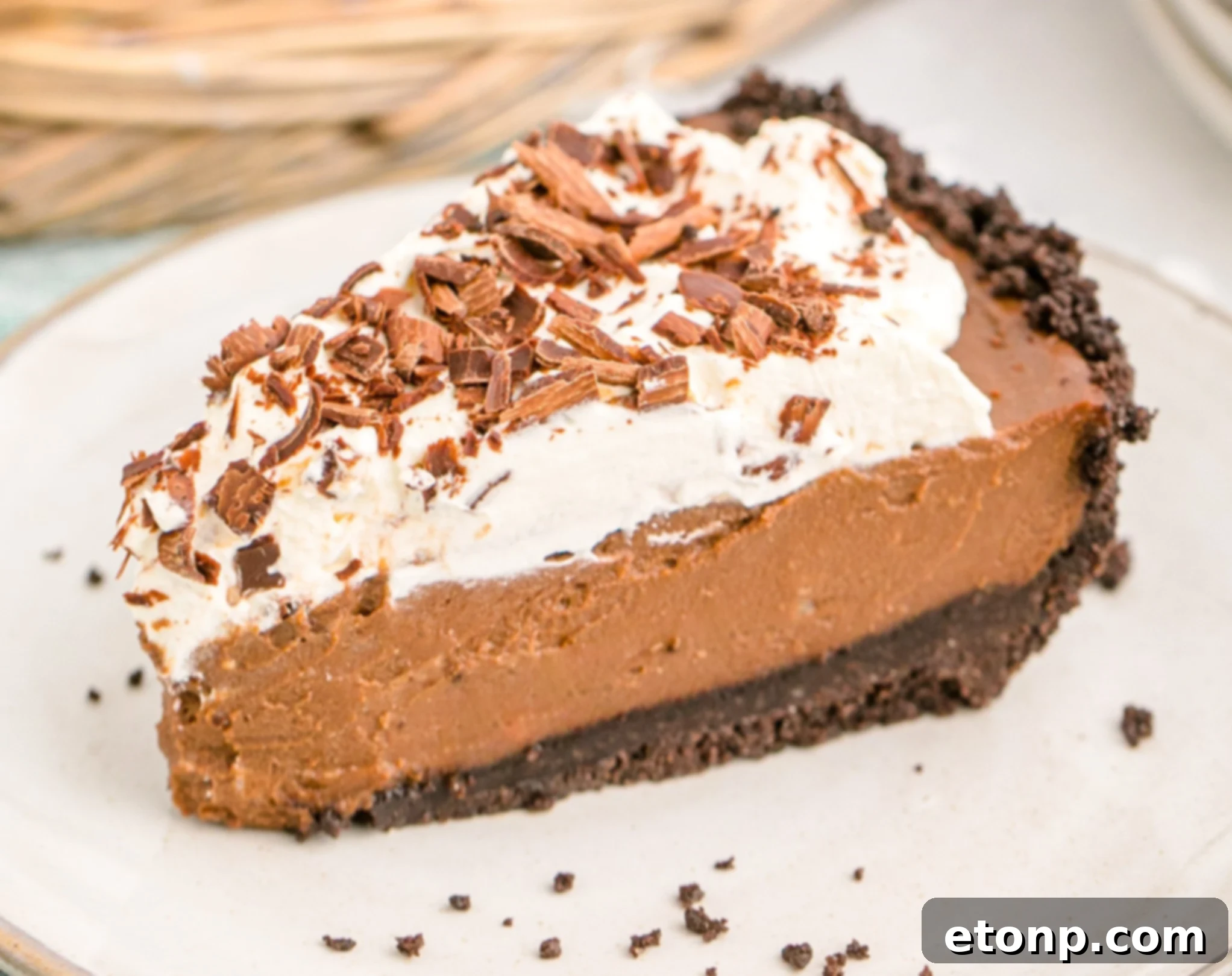 Chocolate Cream Pie topped with whipped cream and chocolate shavings on a white plate, close-up texture
