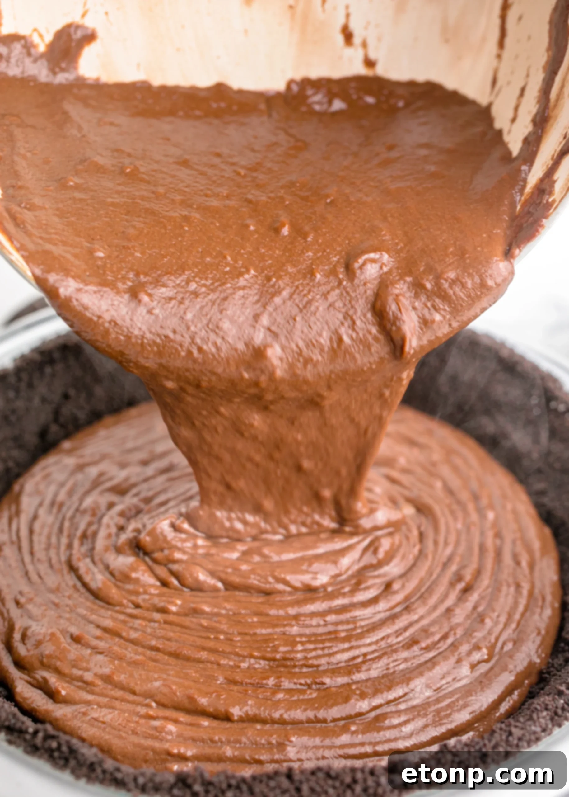 Chocolate Cream Pie filling being poured into an Oreo crust, showcasing the rich texture