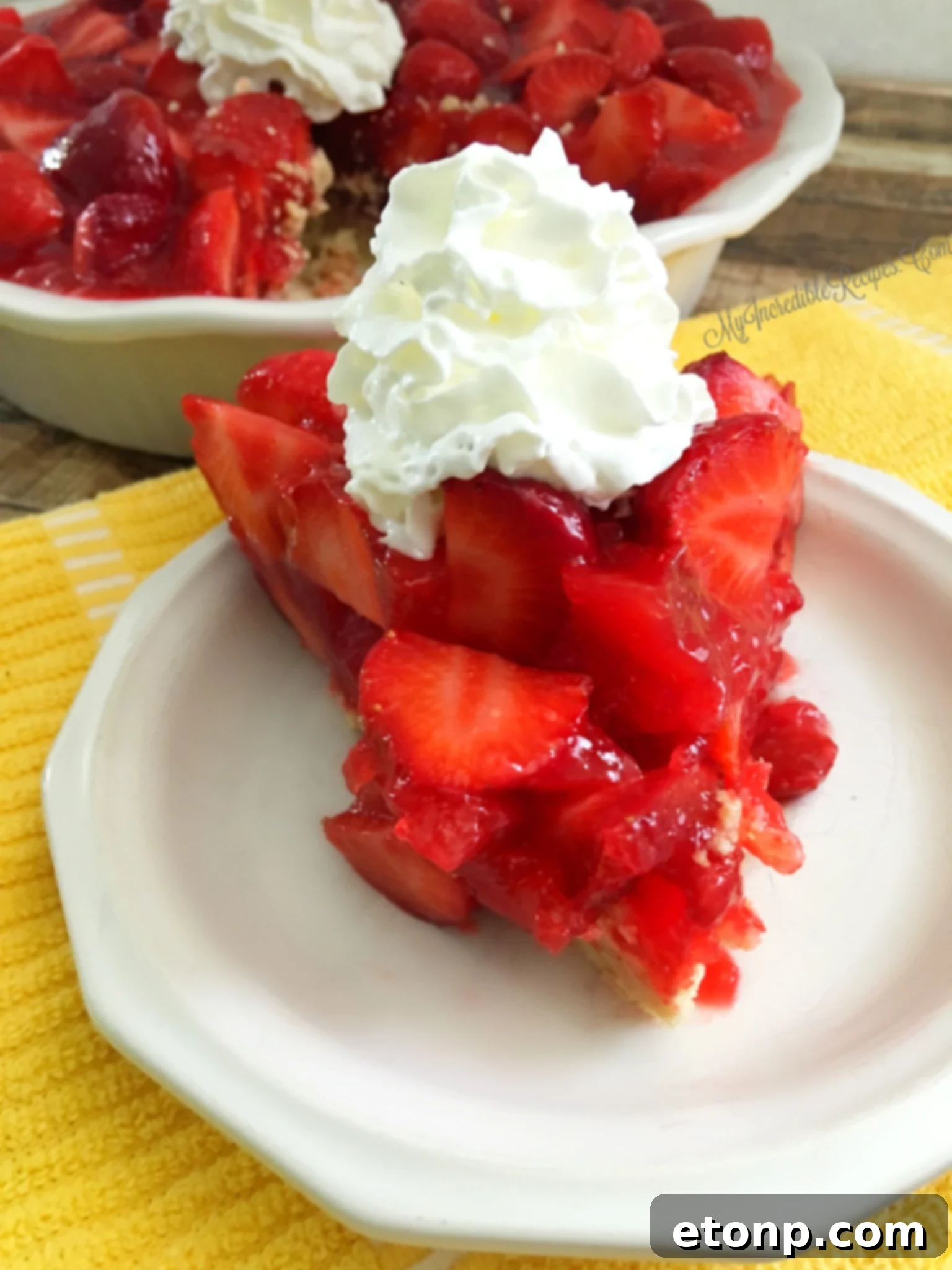 The Ultimate Strawberry Pie 18 Whipped cream being added to a slice of strawberry pie