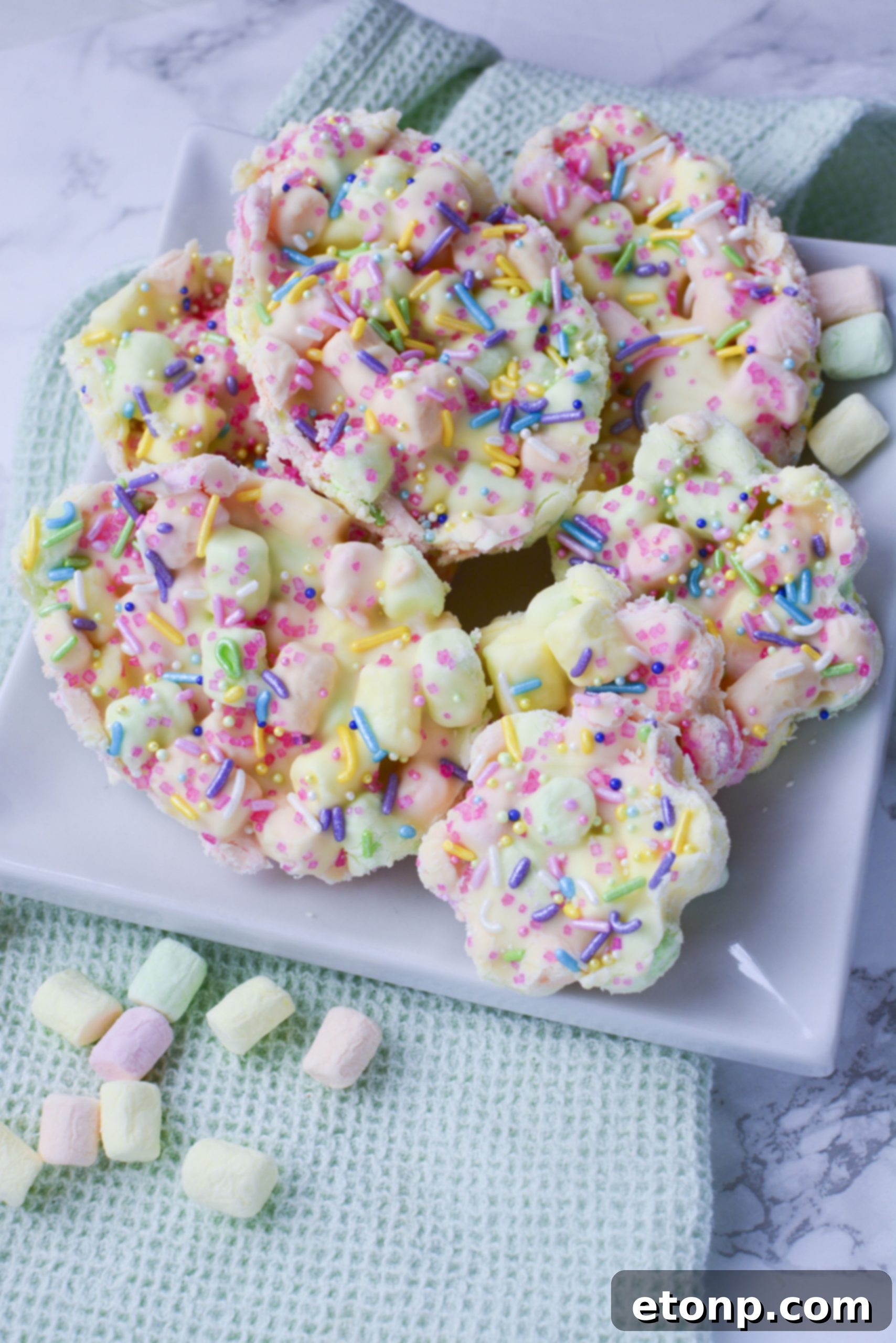 Easter Marshmallow treats with pink, green and yellow mini marshmallows cut into the shape of eggs and flowers