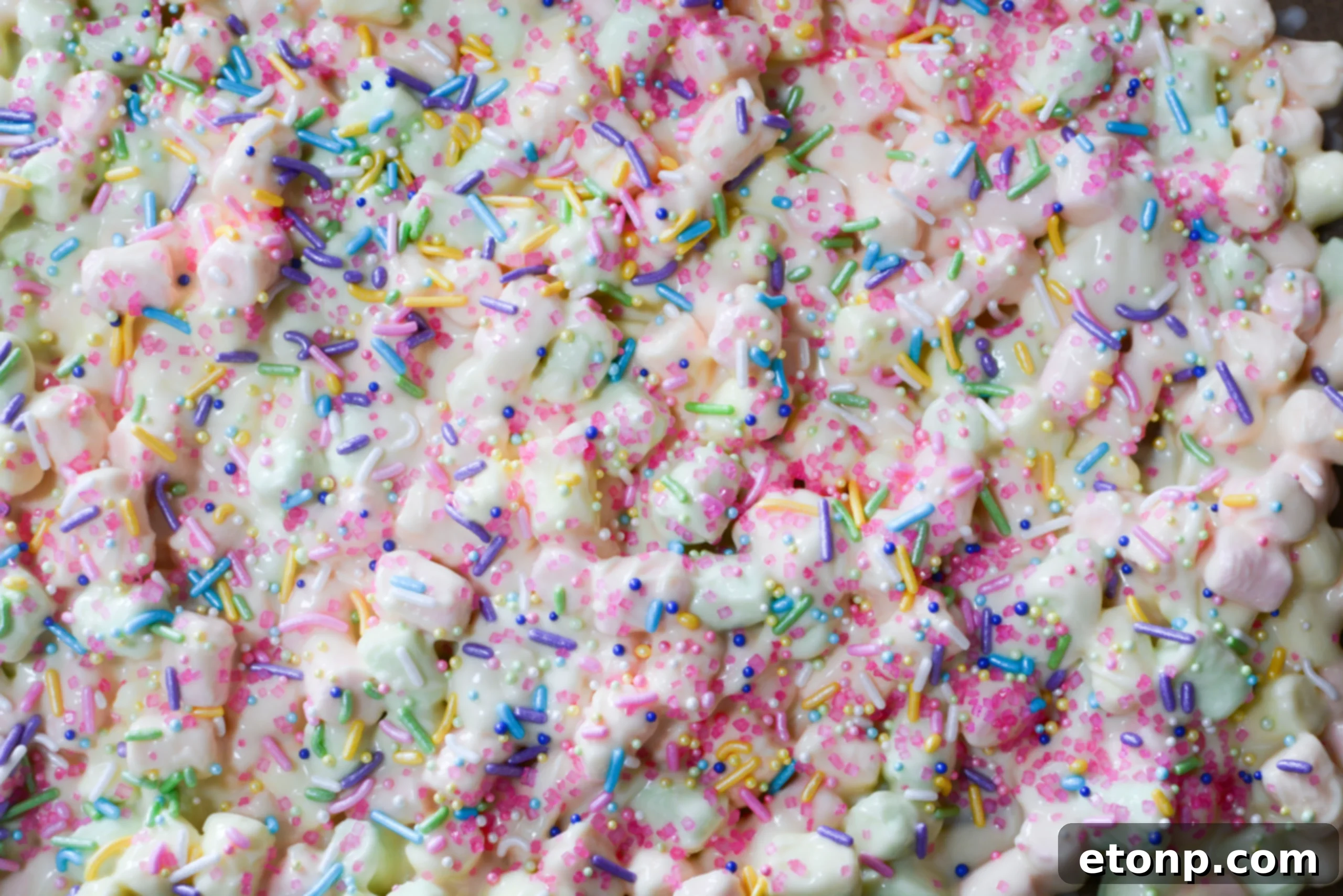 Easter Marshmallow treats with pink, green and yellow mini marshmallows laying on a cookie sheet