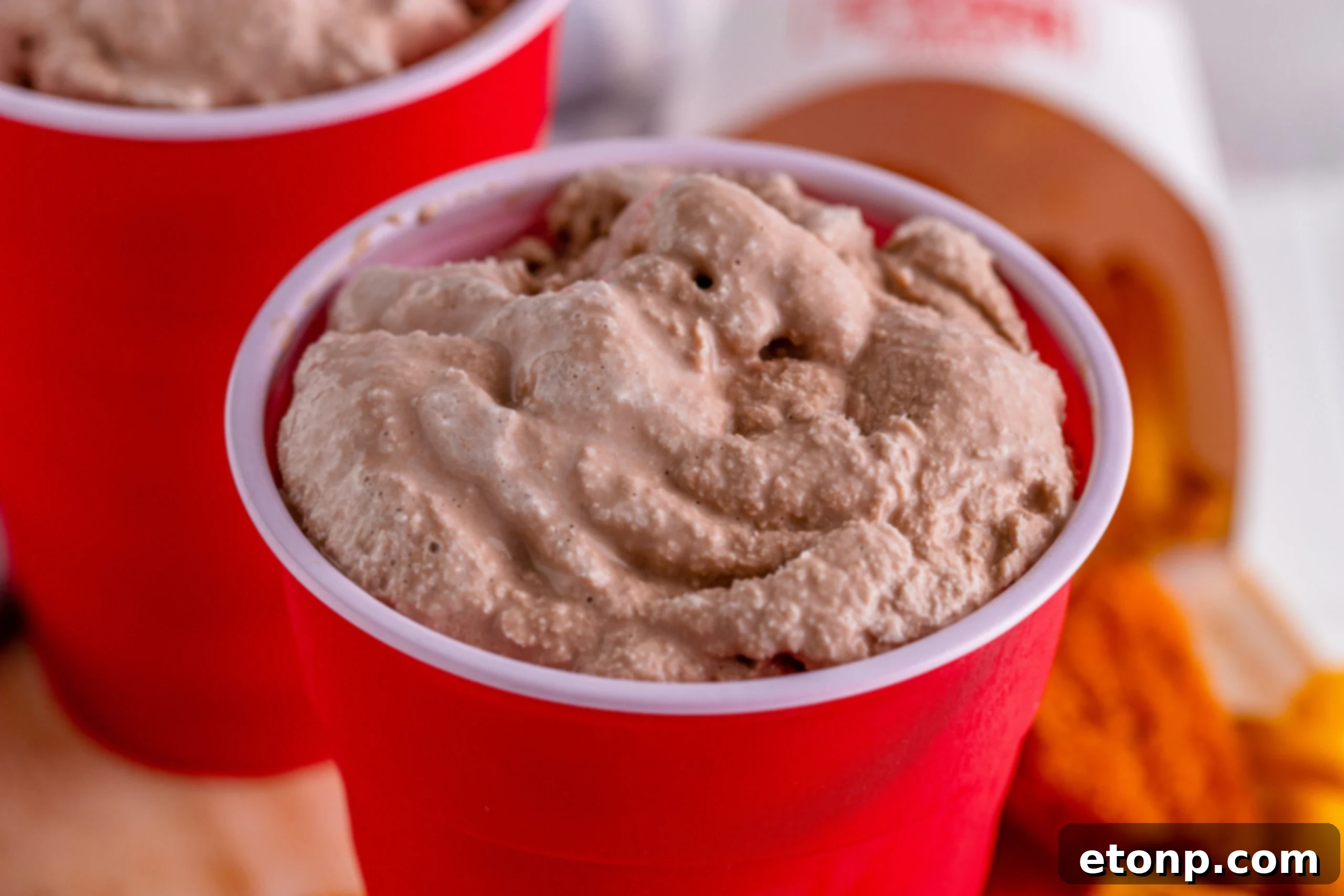 Close-up of a homemade Wendy's Frosty in a red solo cup, showcasing its rich chocolate color and smooth texture.