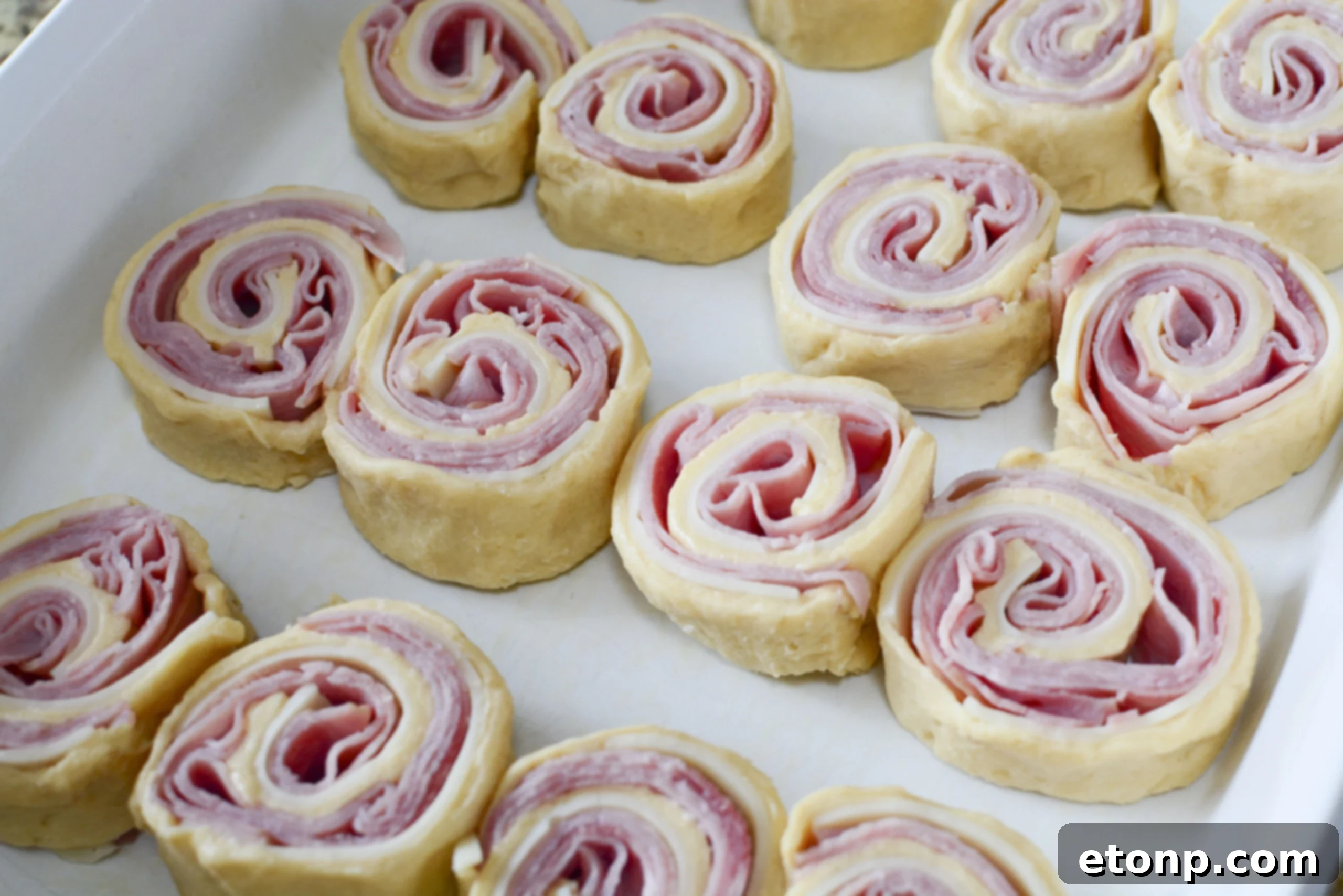 Ham and Cheese Pinwheels in a white baking dish unbaked