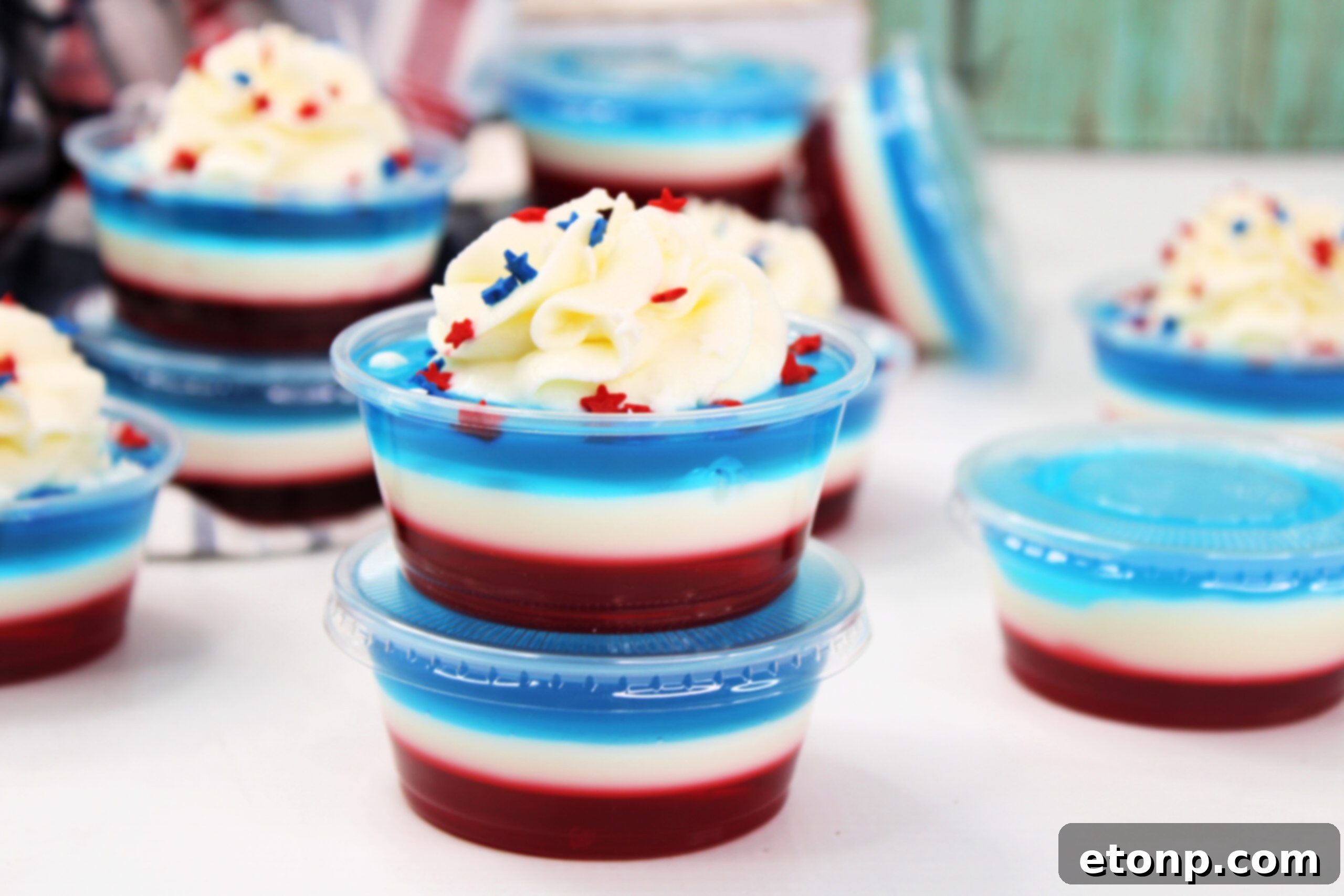 Bomb Pop Jello Shot layered red, white & blue topped with whipped cream and sprinkles