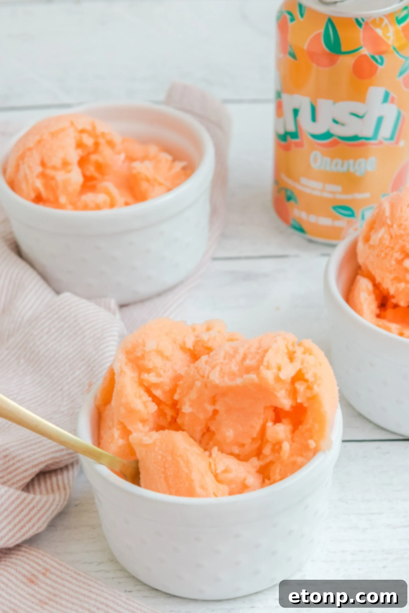 Sunburst Orange Sherbet 8 Orange Crush Sherbet in a white bowl with a gold spoon ready to taste