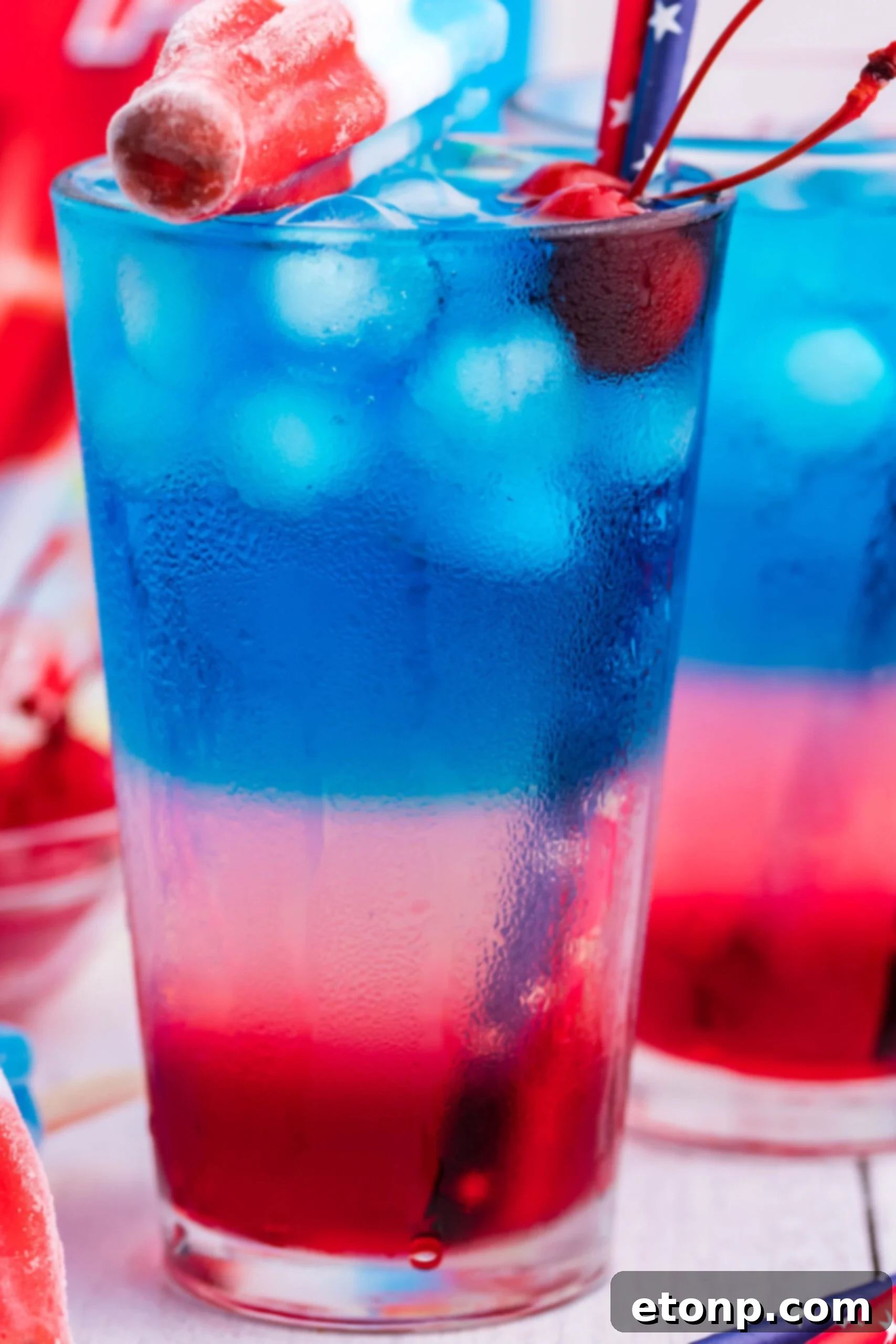 Bomb Pop Cocktail Drink in a clear glass with a blue straw
