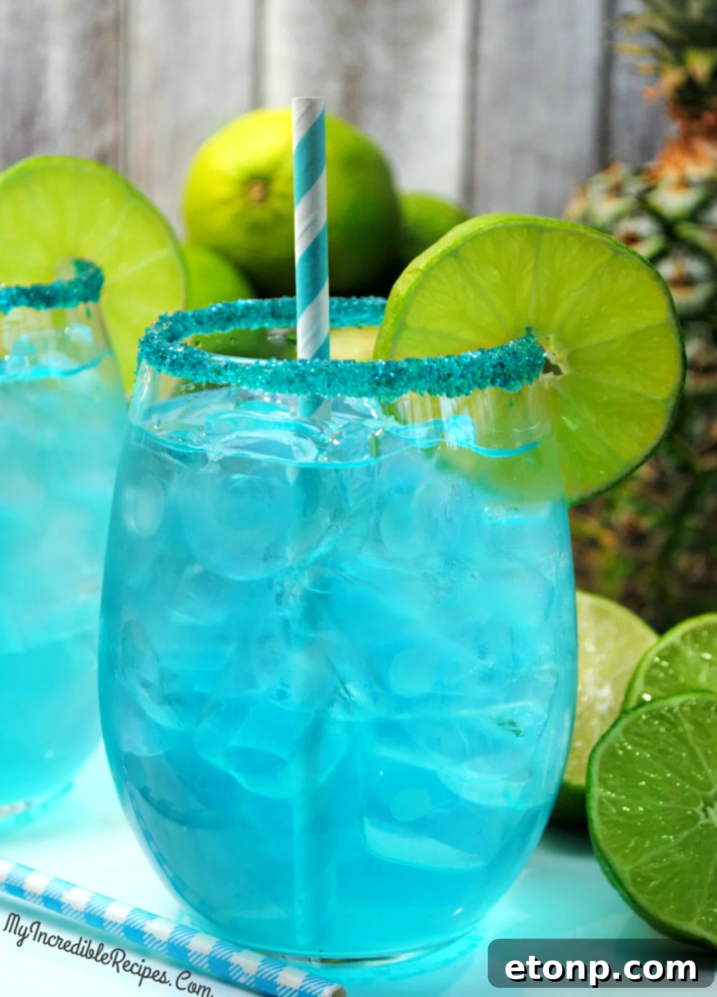 Deliciously vibrant Kinky Pineapple Margarita in a salt-rimmed glass, garnished with a lime wheel.