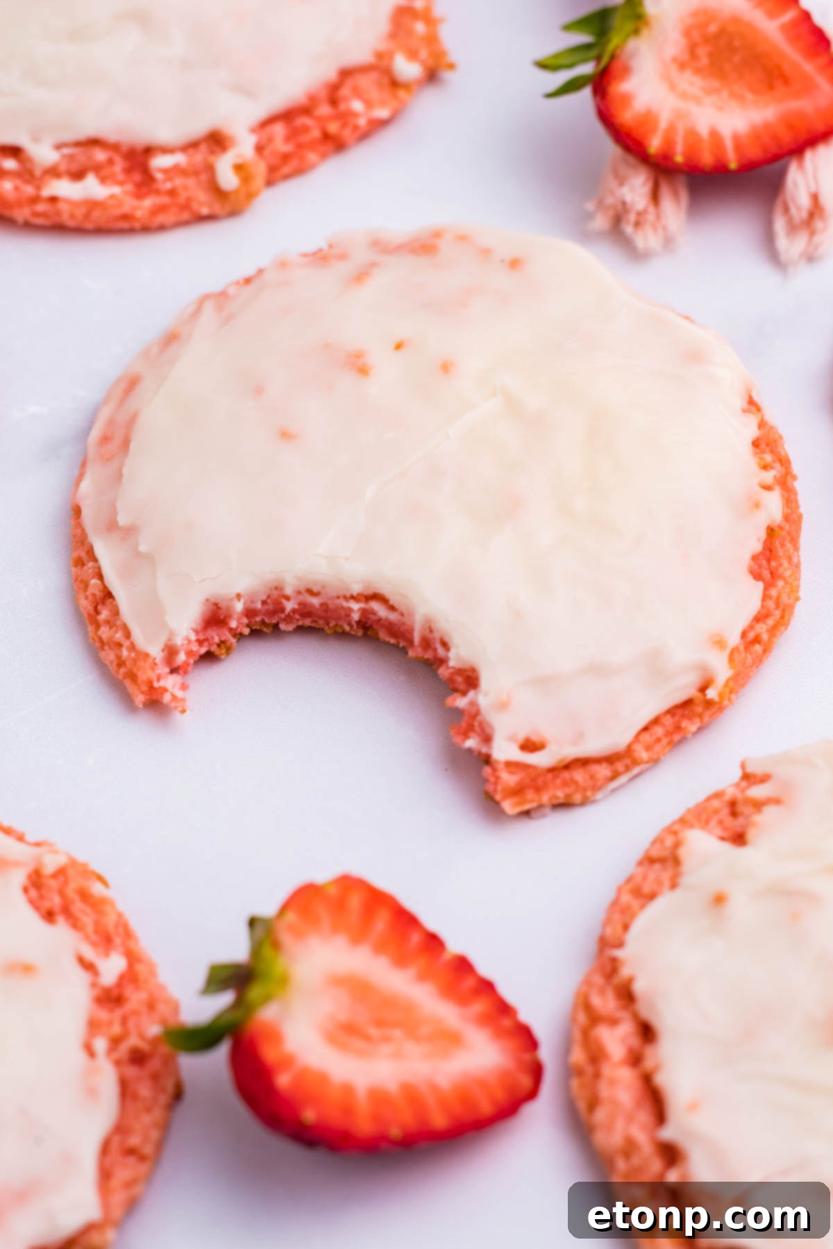 Overhead angle shot of a Strawberry Cool Whip Cookie with a bite taken out